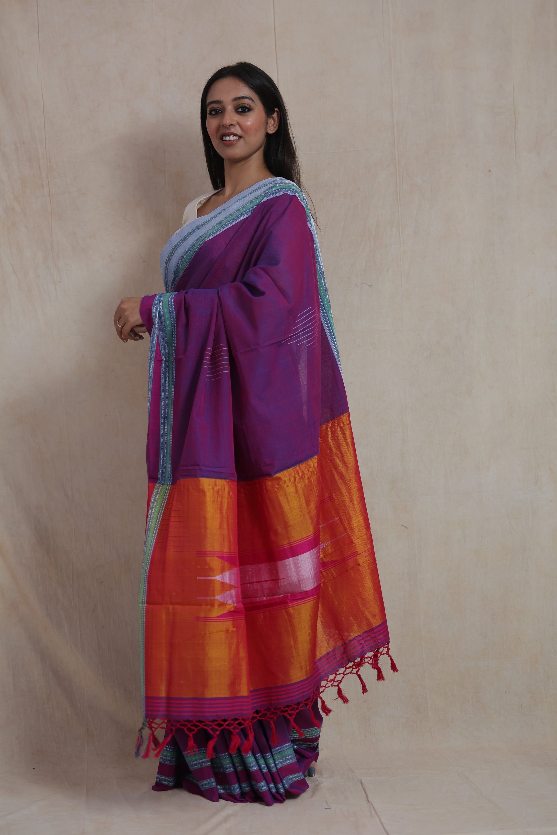 Side profile of traditional purple Ilkal cotton saree featuring vibrant orange pallu