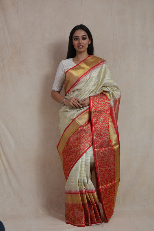 Model wearing ivory Venkatagiri silk saree with coral red woven border and floral pallu