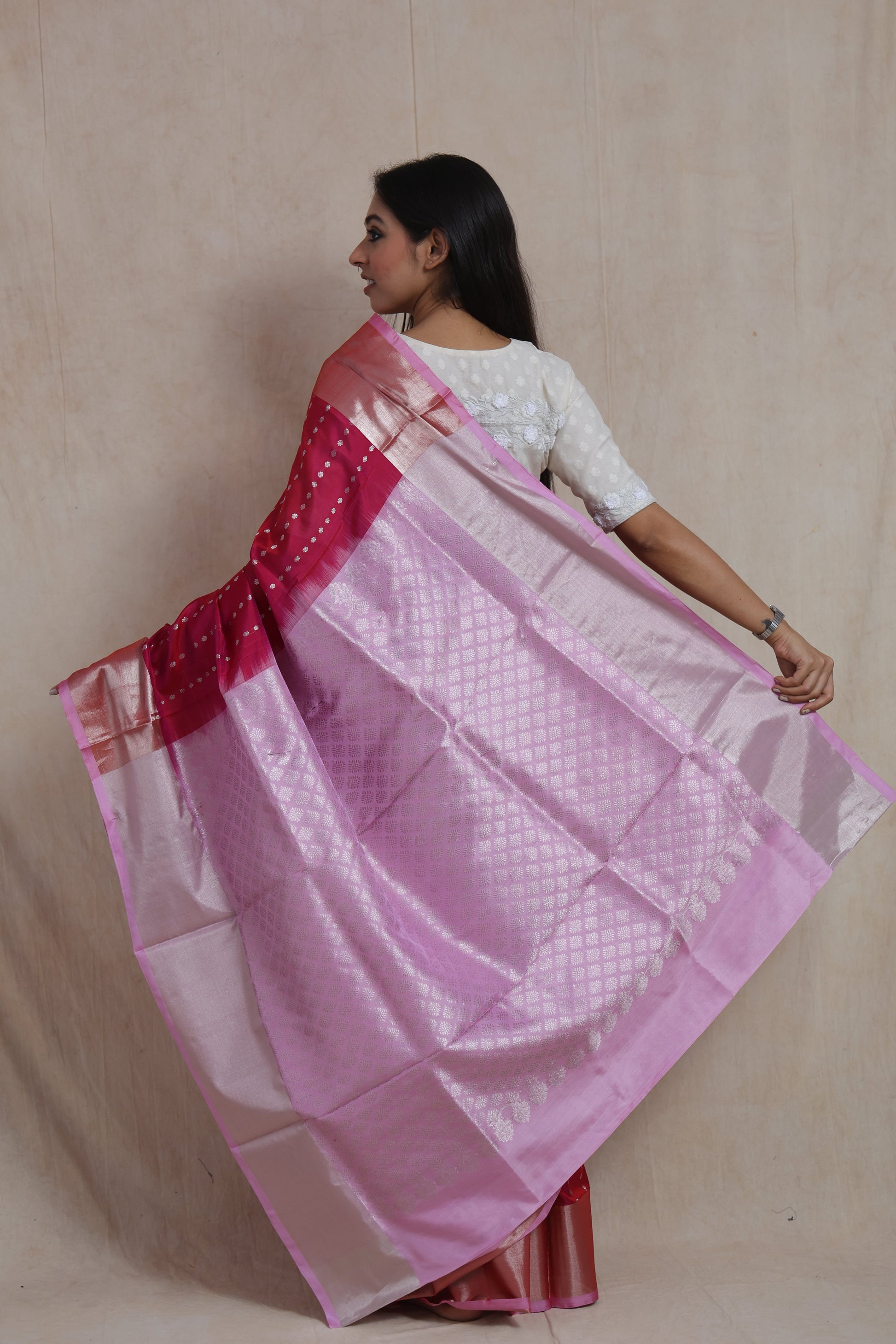 Back view showcasing the intricately woven pastel pink pallu of a rani pink Kanjivaram silk saree