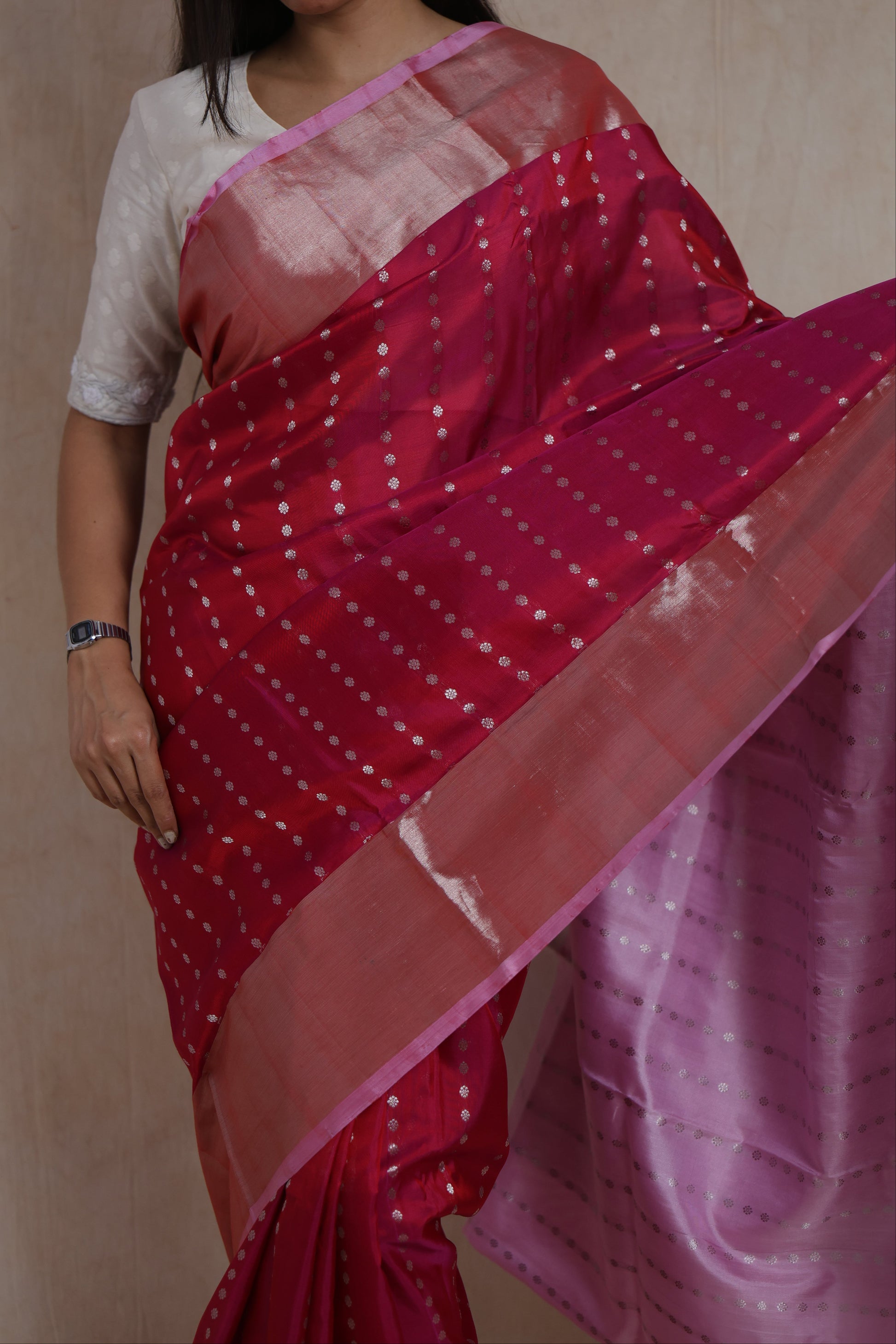 Close-up of silver woven motifs on rani pink Kanjivaram silk saree with shimmering border