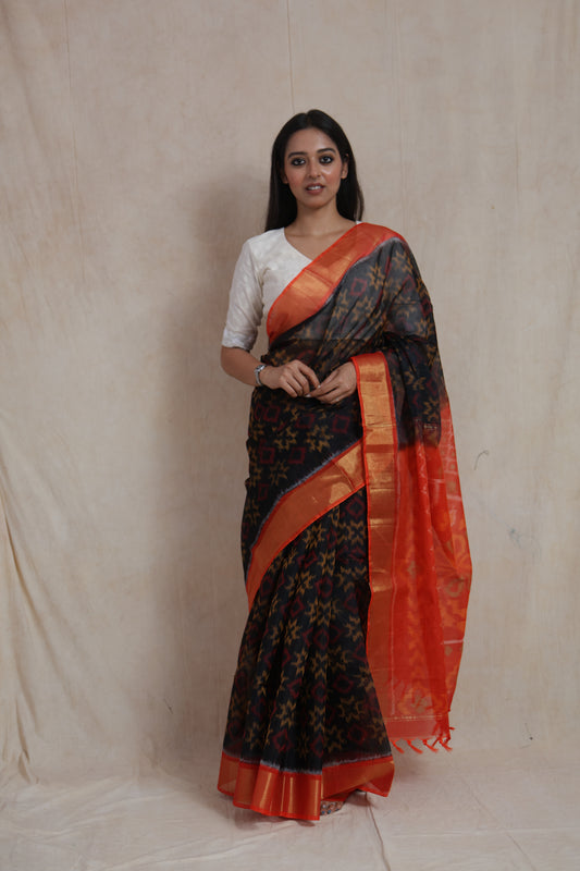 Full front view of black Panchampali SICO saree with vermilion orange border and traditional ikat motifs
