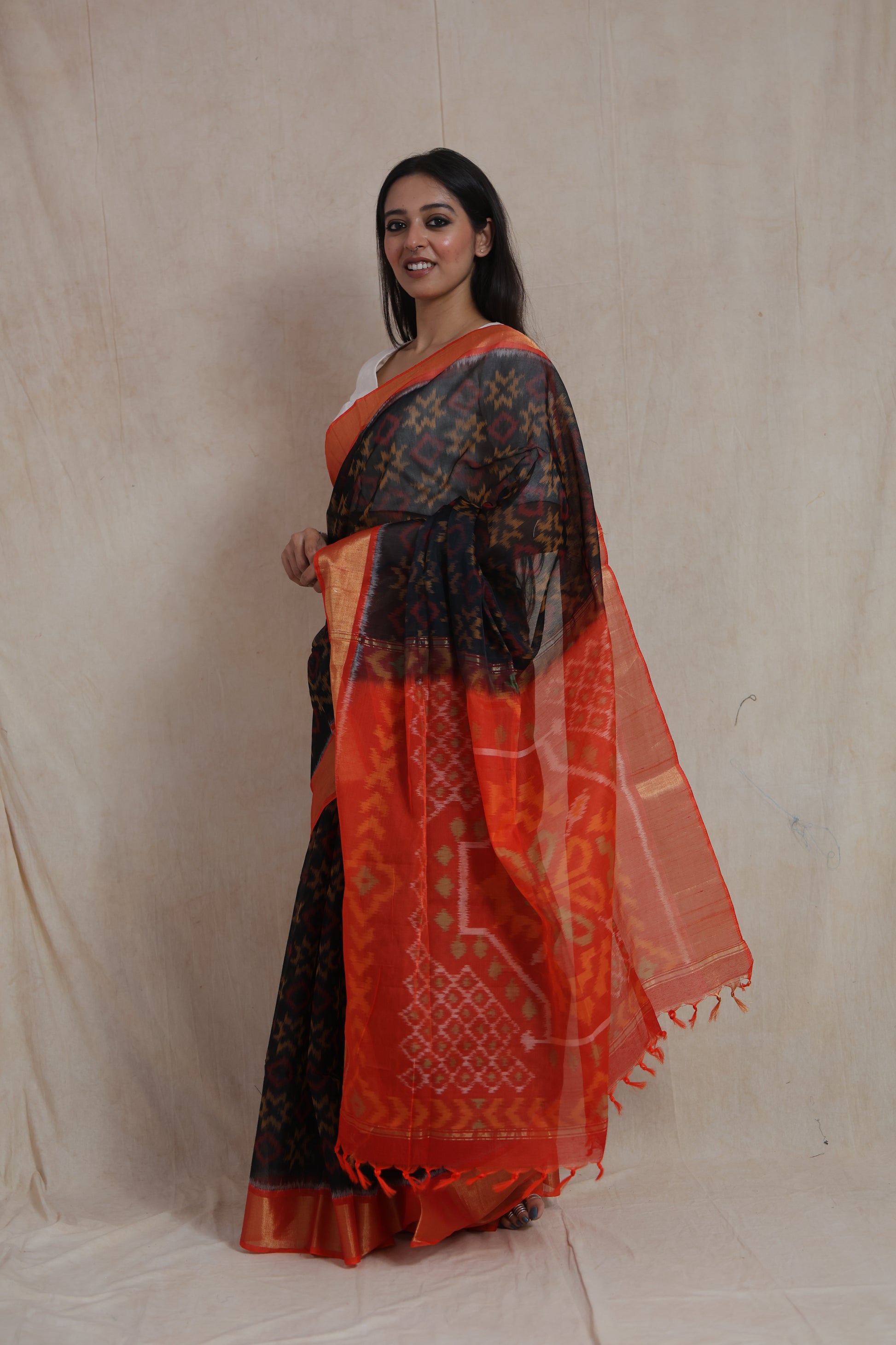 Side profile of black Panchampali SICO saree showcasing vibrant orange pallu and woven ikat patterns