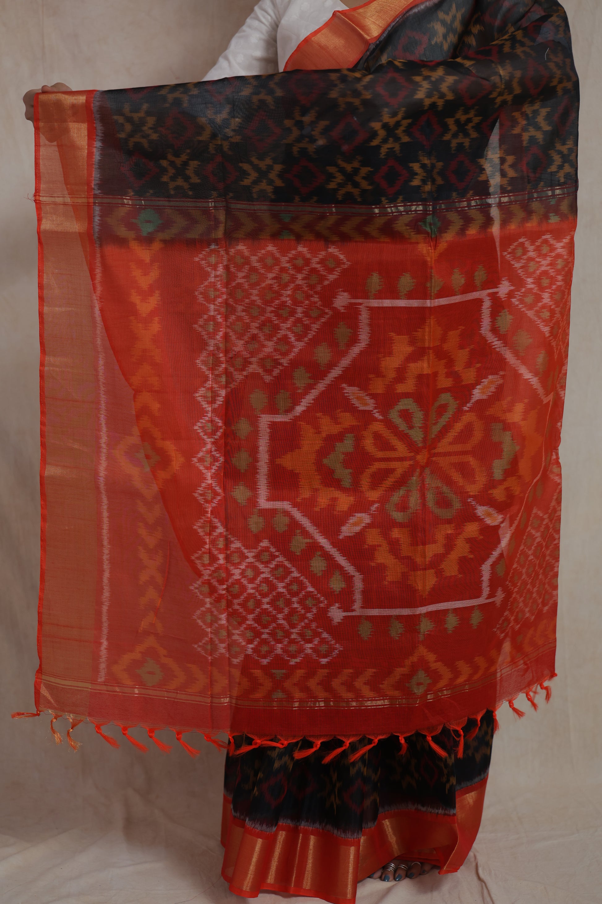 Close-up of orange contrast pallu featuring traditional Panchampali ikat weaving and tassel finish