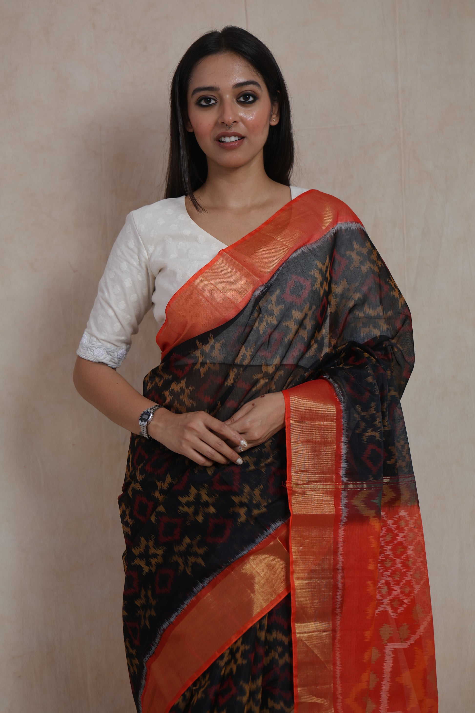 Close-up of the black Ikat woven body featuring geometric motifs and vibrant orange border.