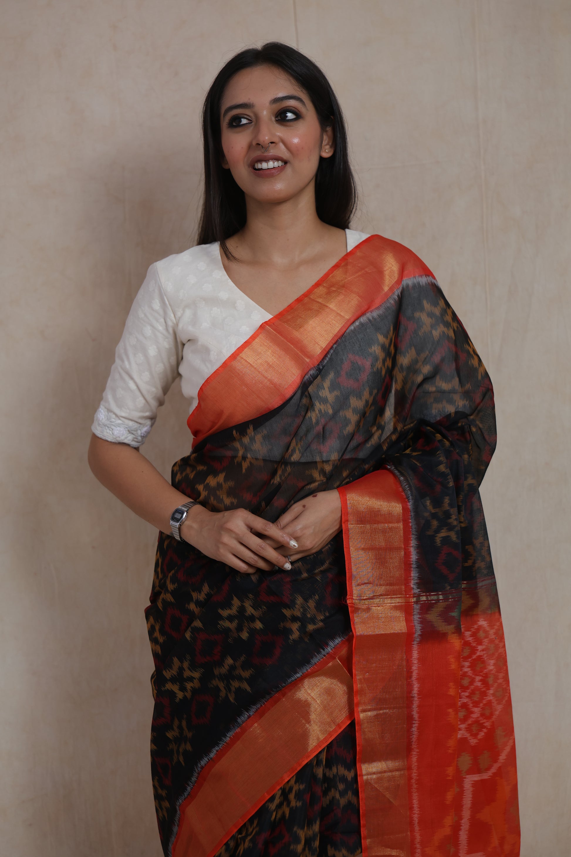 Close-up portrait showcasing black Panchampali SICO saree with vibrant orange woven border and pallu
