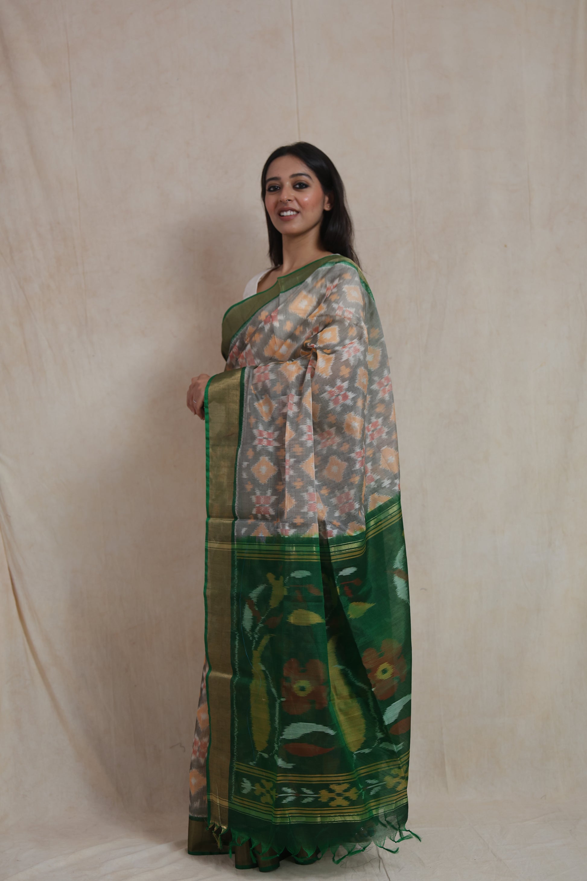 Side view of grey Pochampally SICO saree showcasing the elegant green border and artistic woven pallu.