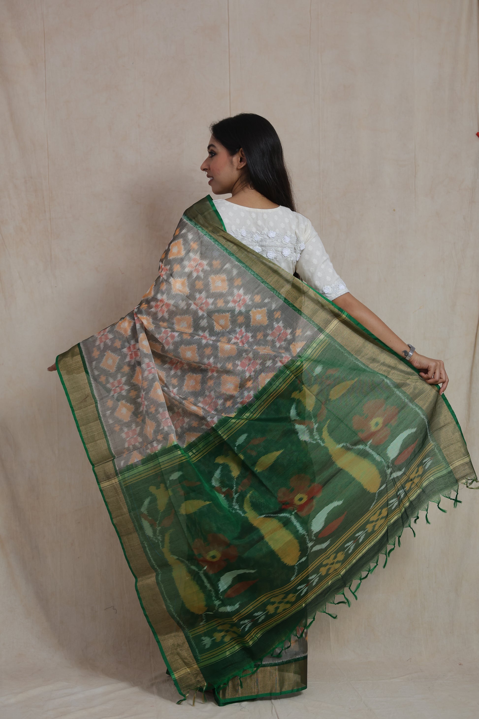 Back view of grey Pochampally SICO saree displaying the intricate floral Ikat pallu and rich green border.