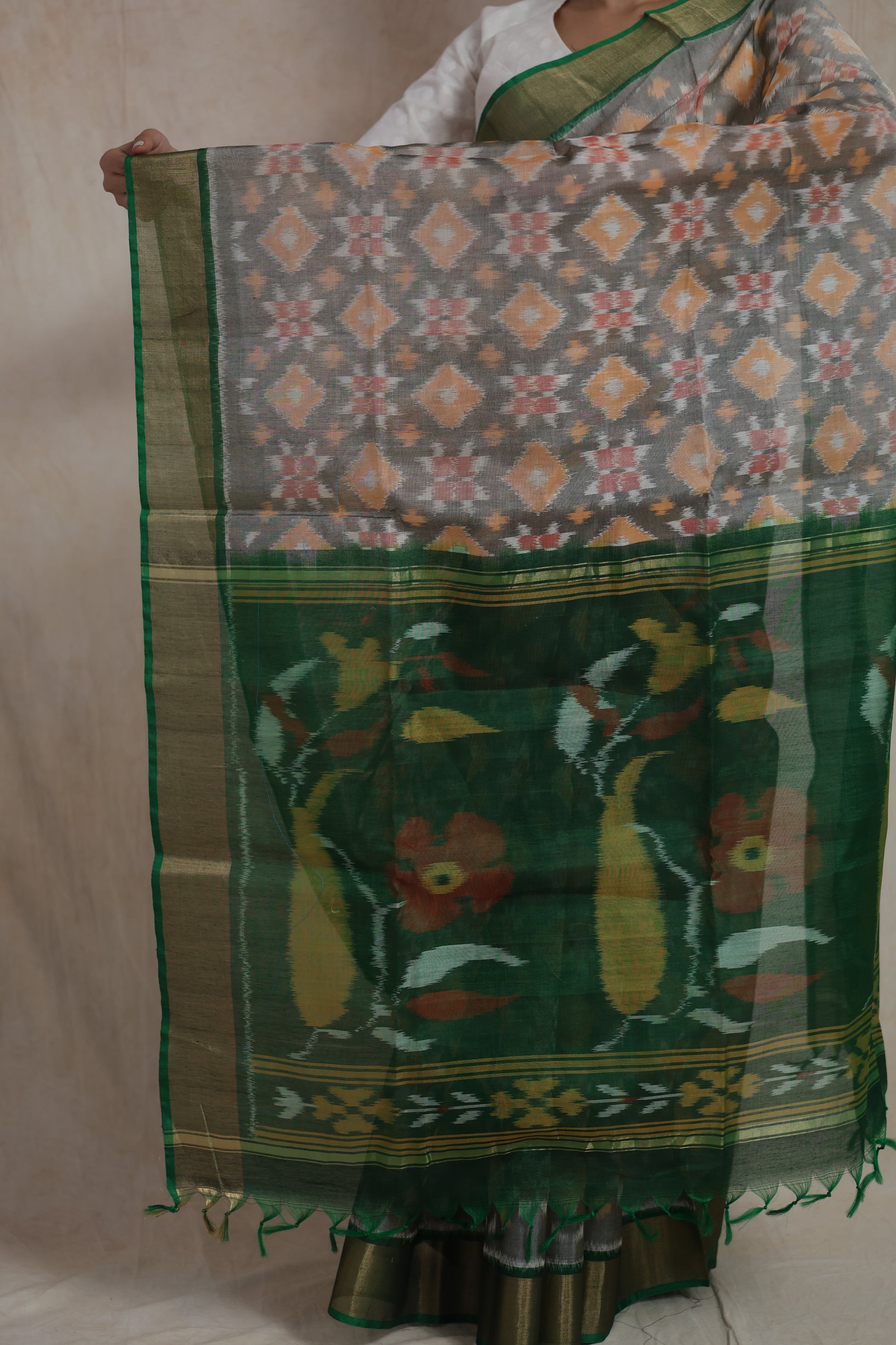 Detailed view of the floral woven pallu and green border of the grey Pochampally SICO saree.