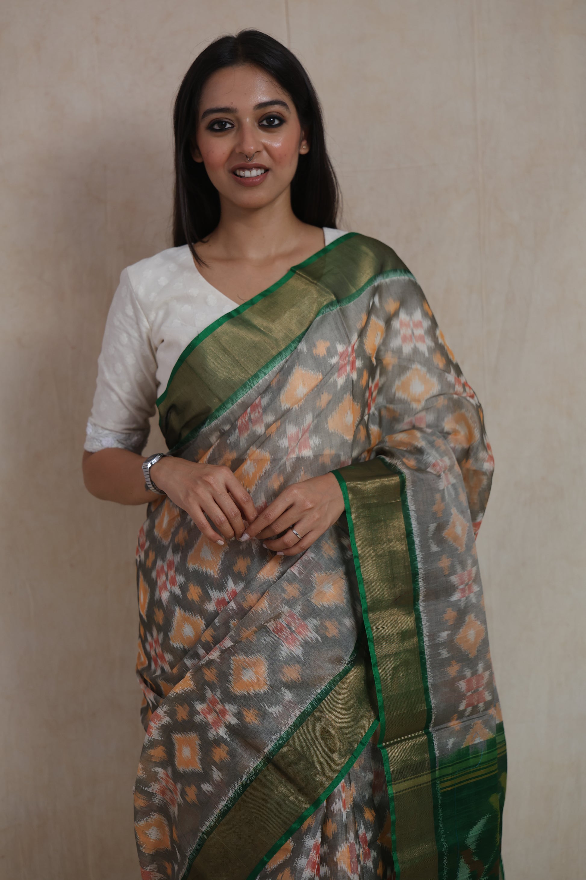 Portrait view of the elegant grey Pochampally SICO saree featuring traditional Ikat weaving and emerald green border.