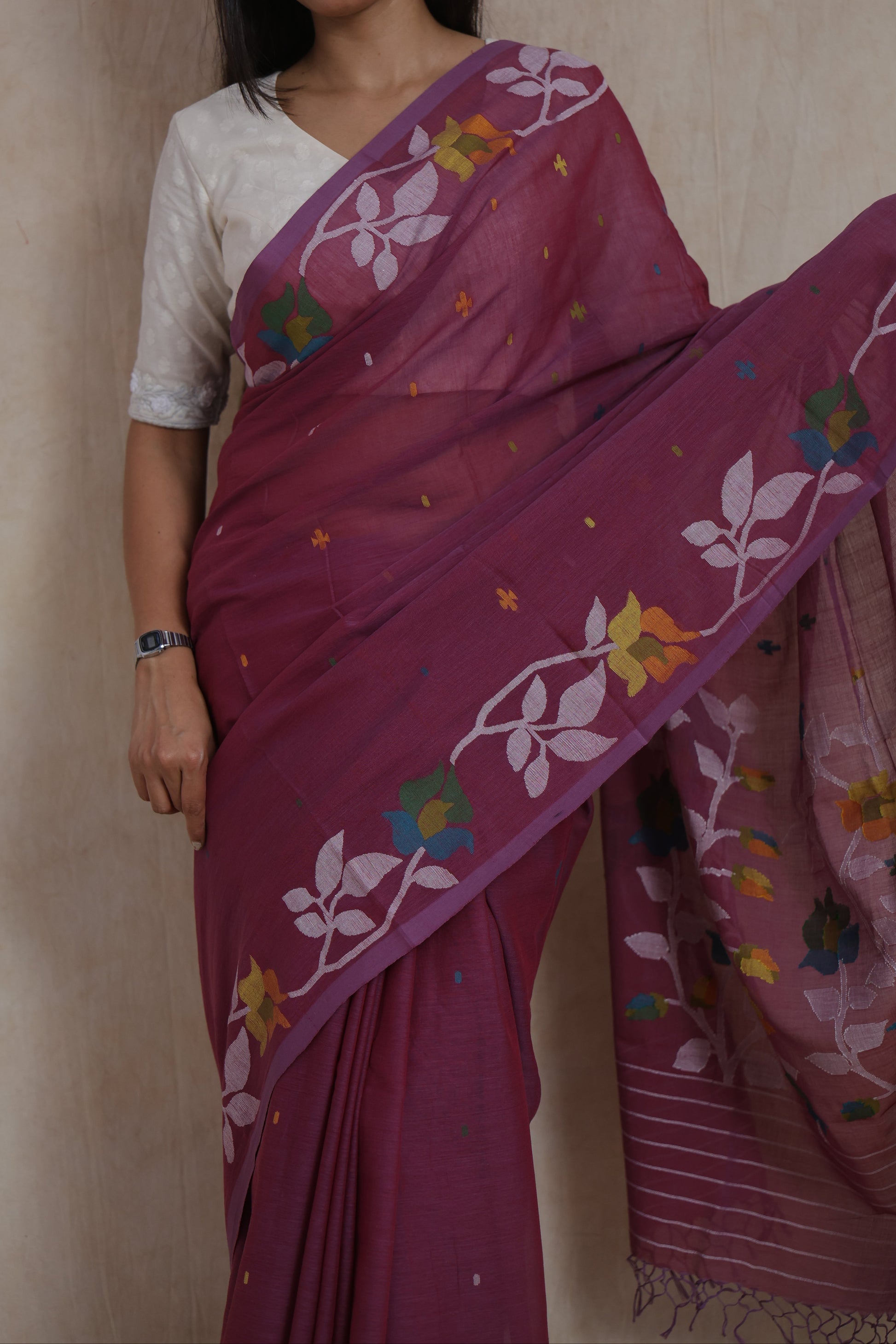 Close-up of royal plum Bengal Cotton Fulia saree showcasing floral woven border and delicate buttas