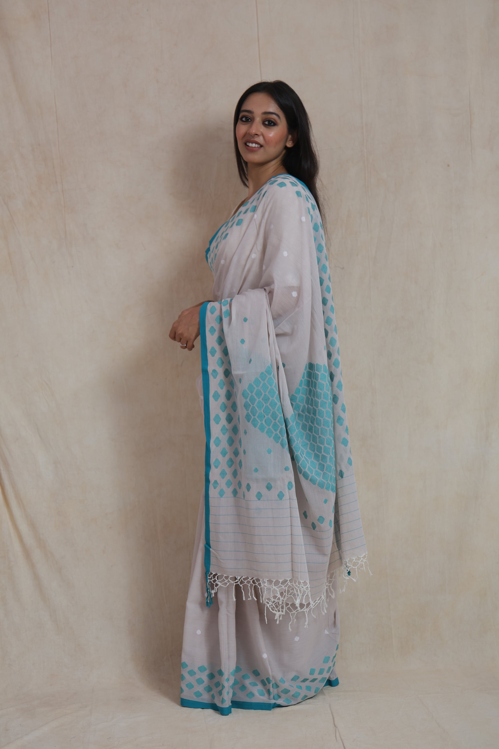 Side profile of handwoven Bengal Cotton Fulia saree featuring aqua blue geometric motifs
