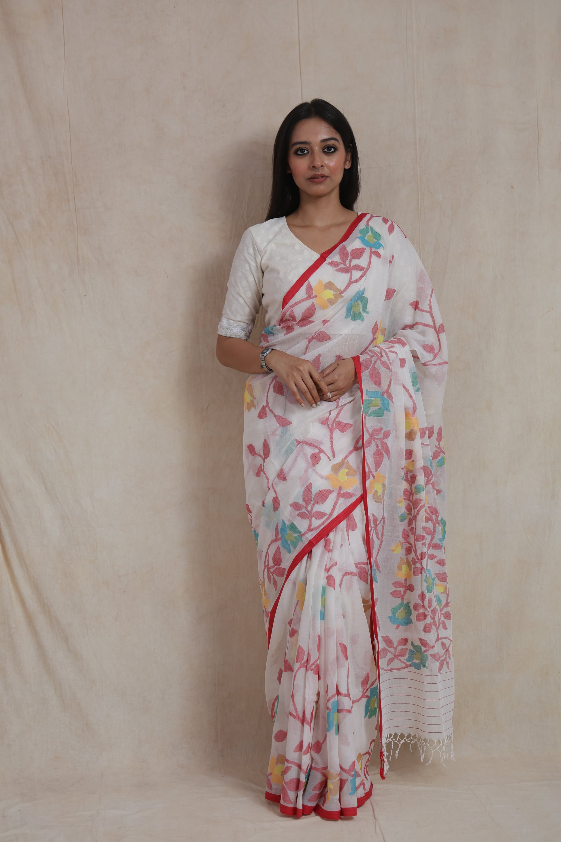 Front view of ivory white Bengal Cotton Fulia saree with multicolor floral woven motifs and red border