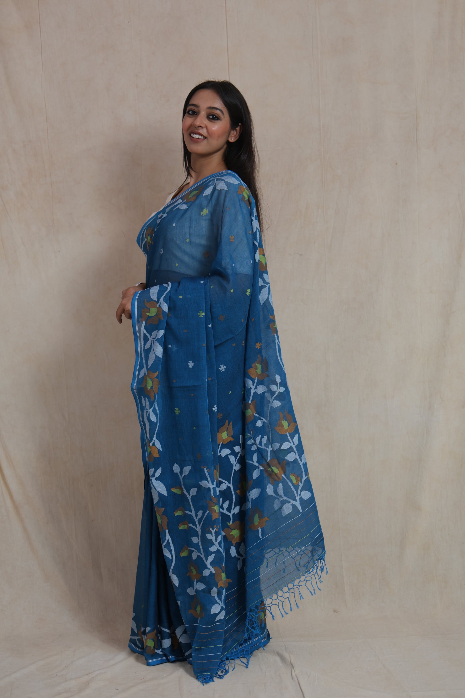 Side profile of royal blue Bengal Cotton Fulia saree showcasing floral border and graceful drape