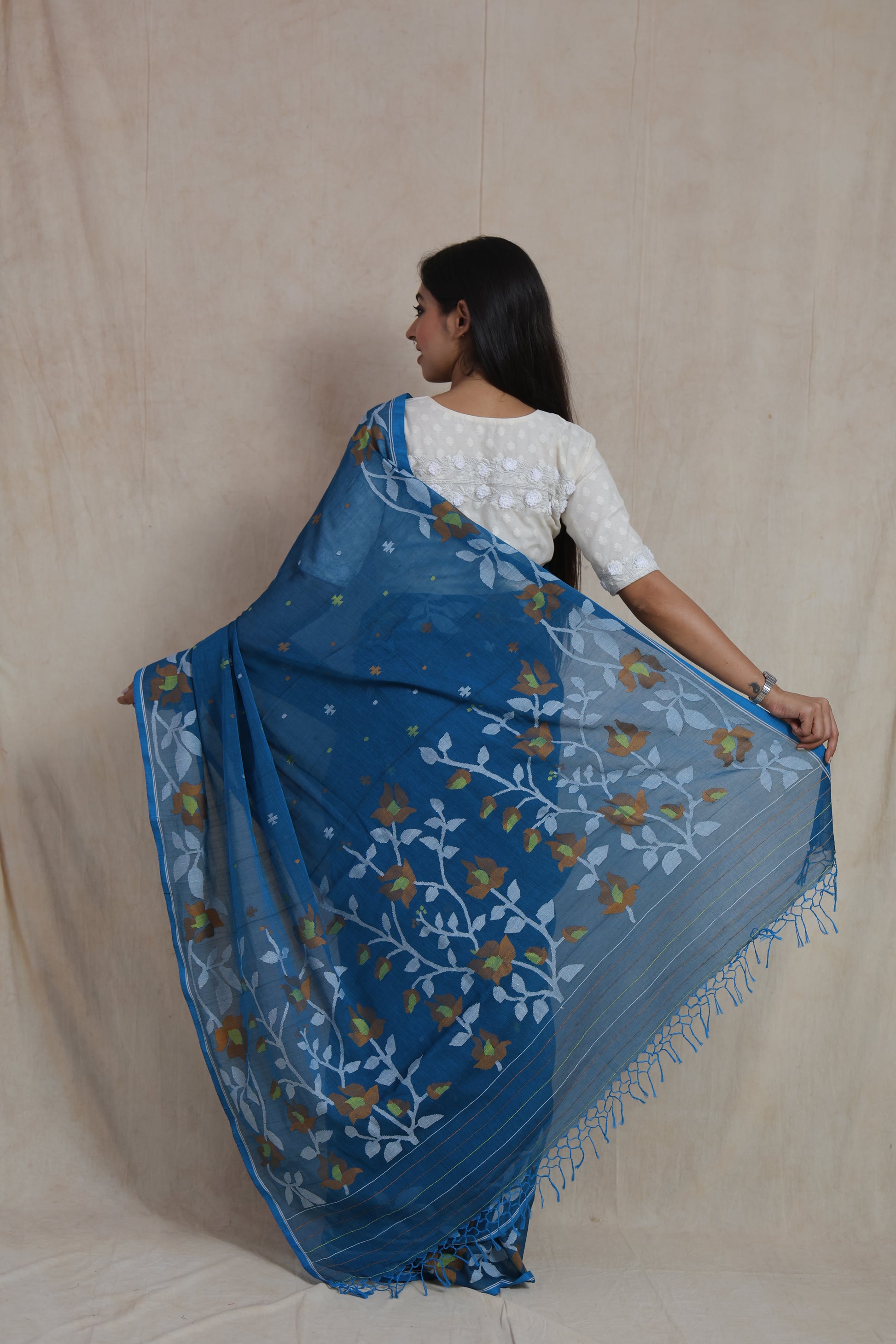 Back view of Bengal Cotton Fulia saree highlighting artistic floral woven pallu and tassel detailing