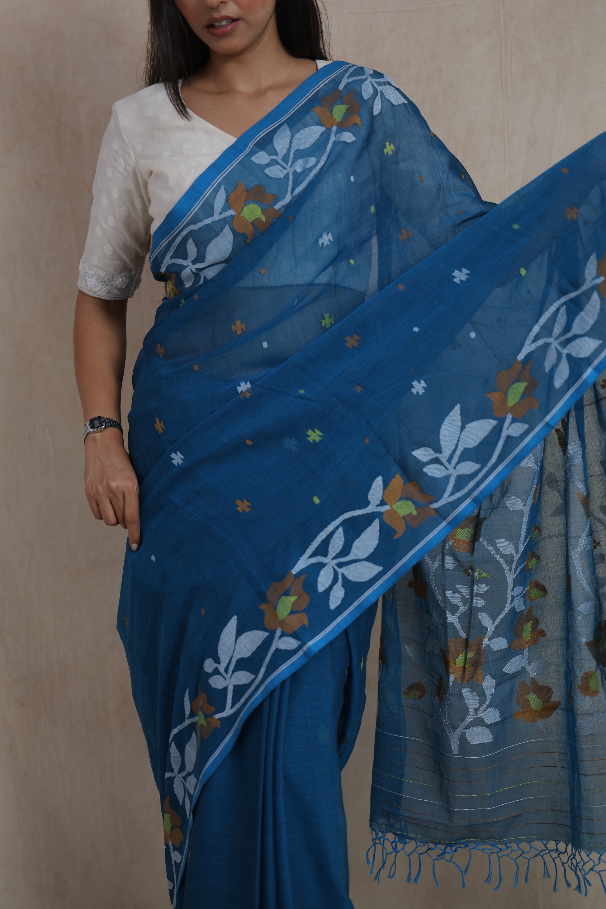 Close-up of royal blue Bengal Fulia cotton saree featuring floral woven border and fine handloom texture