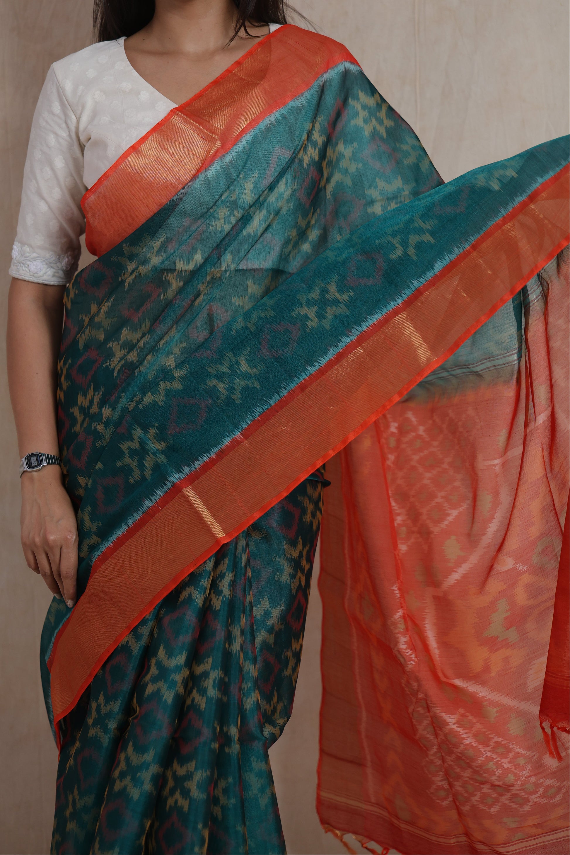 Close-up drape view of Panchampali silk cotton saree featuring teal ikat motifs and orange border