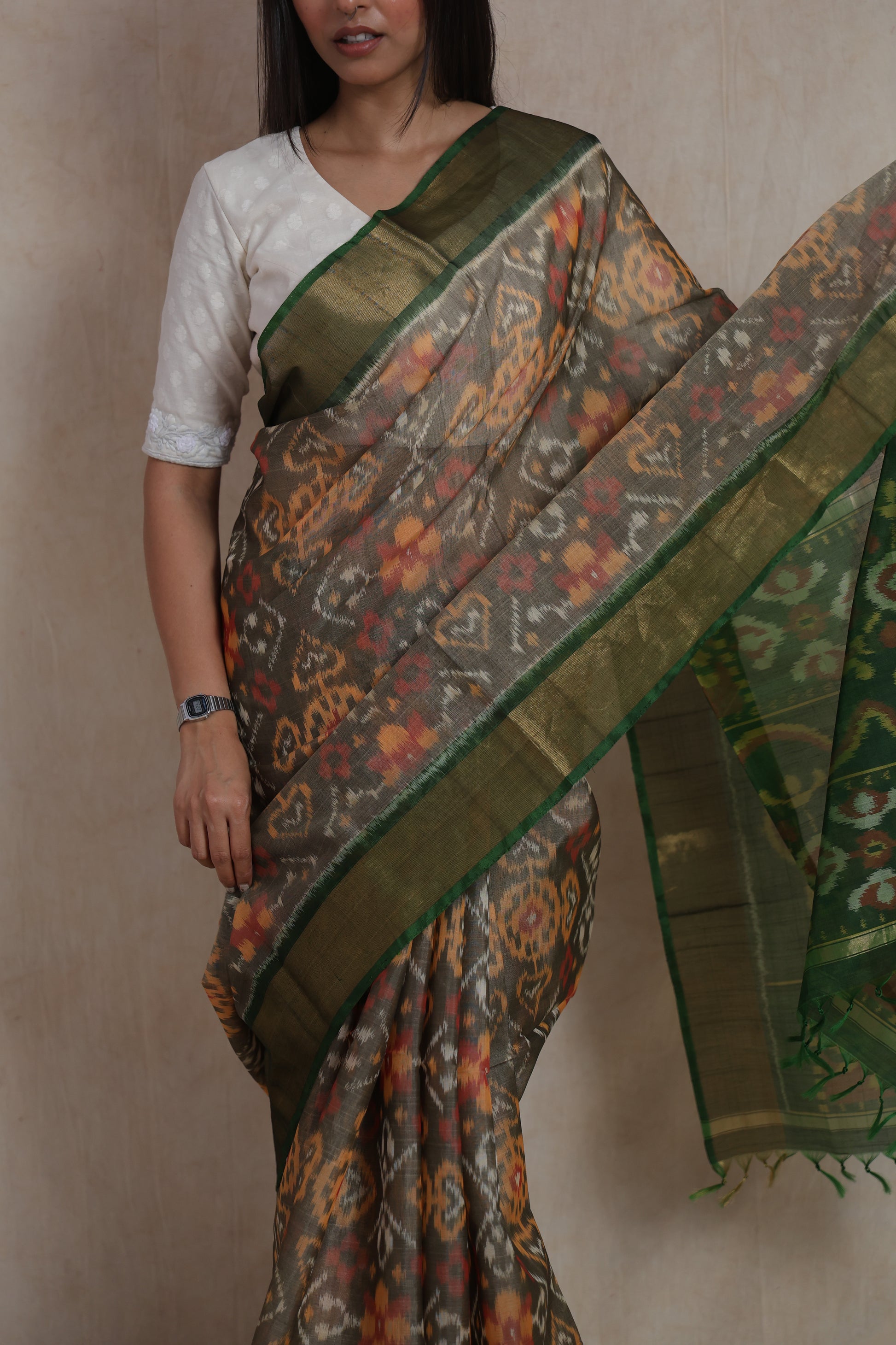 Close-up of earthy taupe Panchampali silk cotton saree with intricate Ikat-inspired motifs and golden border