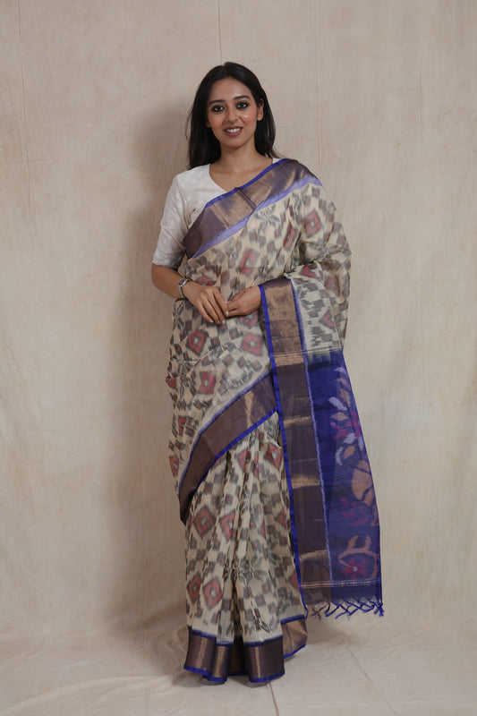 Full front view of ivory Pochampally handloom silk cotton saree with classic Ikat pattern and blue border