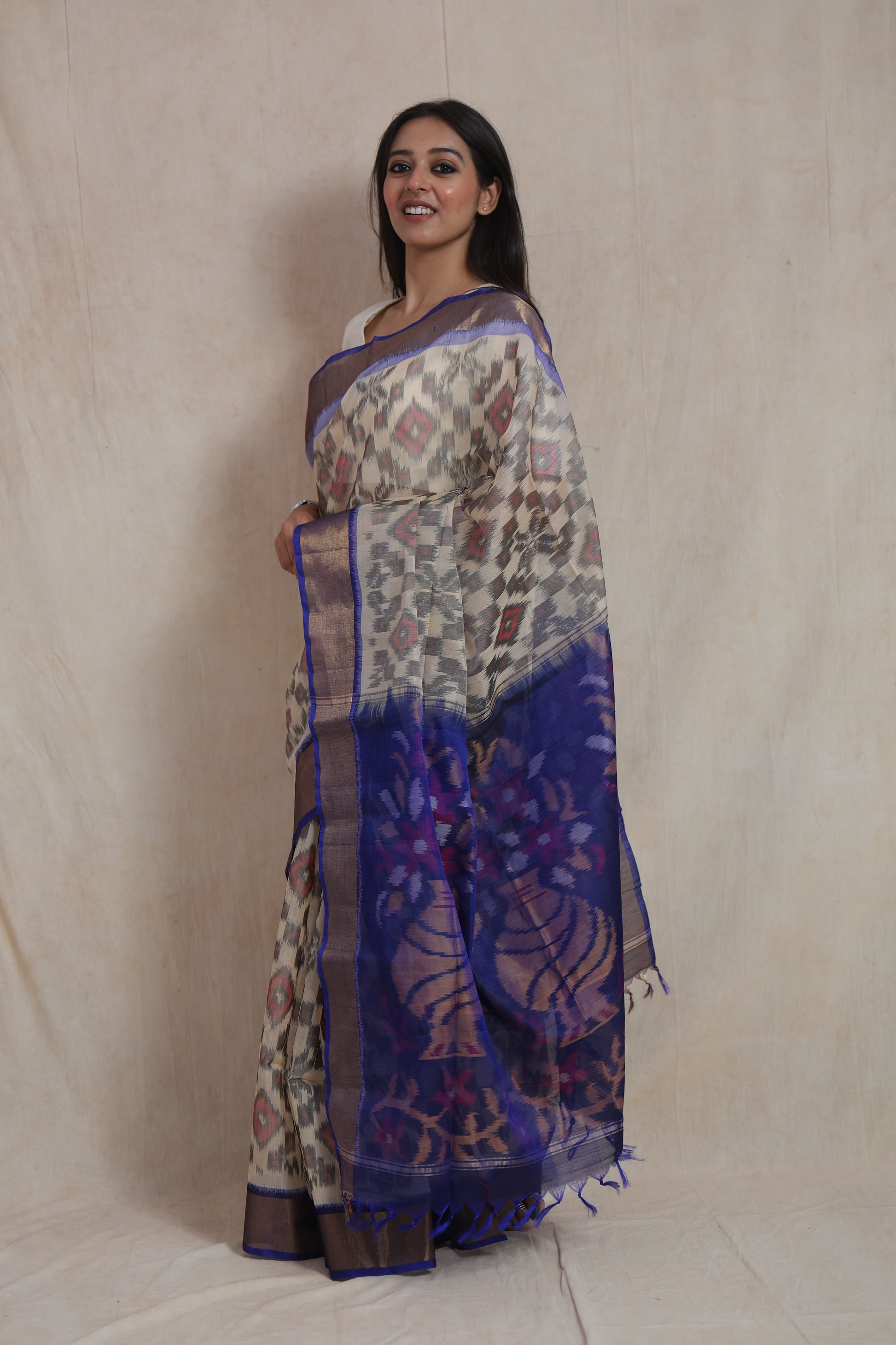 Side profile of ivory Panchampali silk cotton saree highlighting the floral blue pallu and handcrafted weave