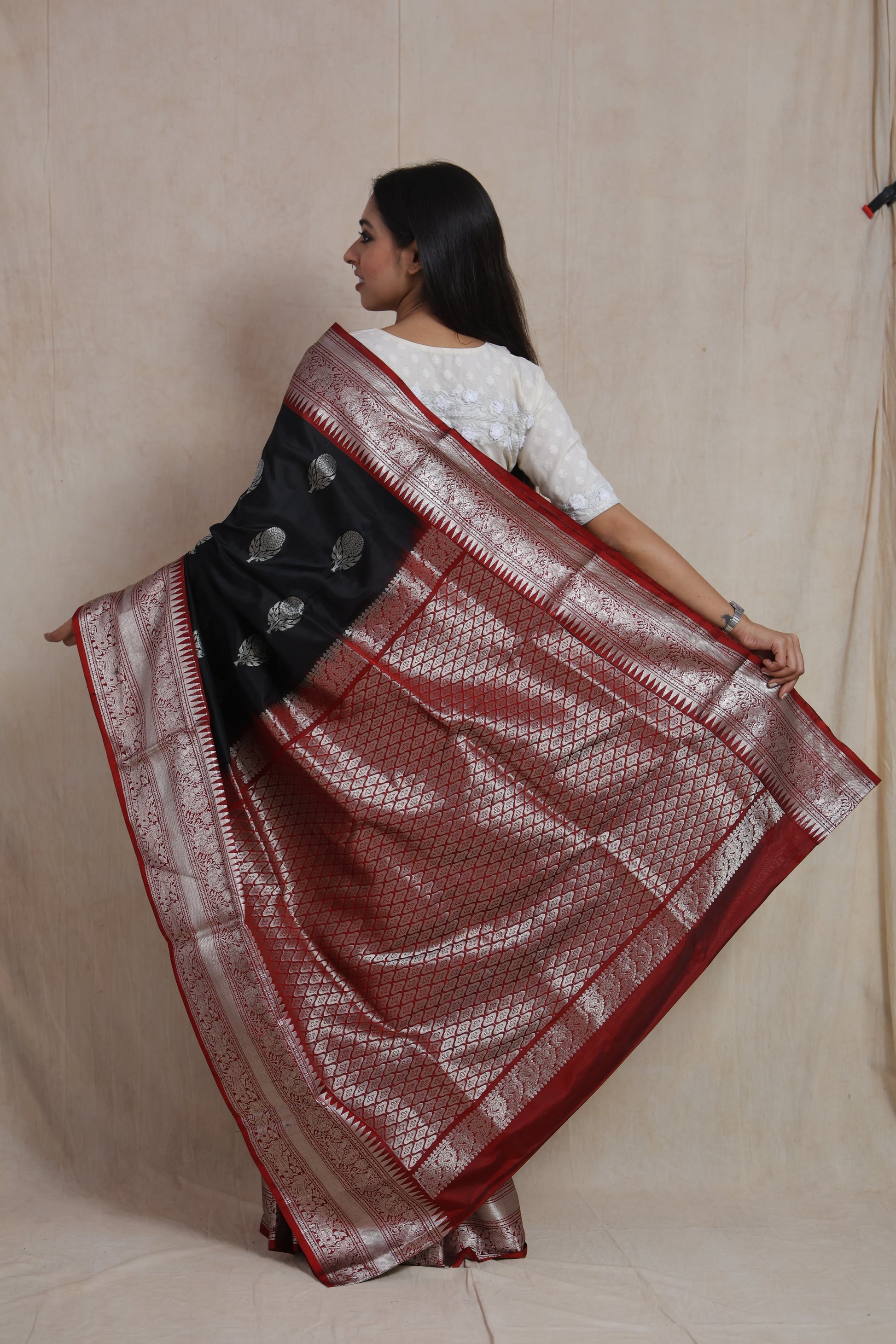 Back view highlighting the richly woven pallu and intricate border of the black Kanjivaram silk saree.