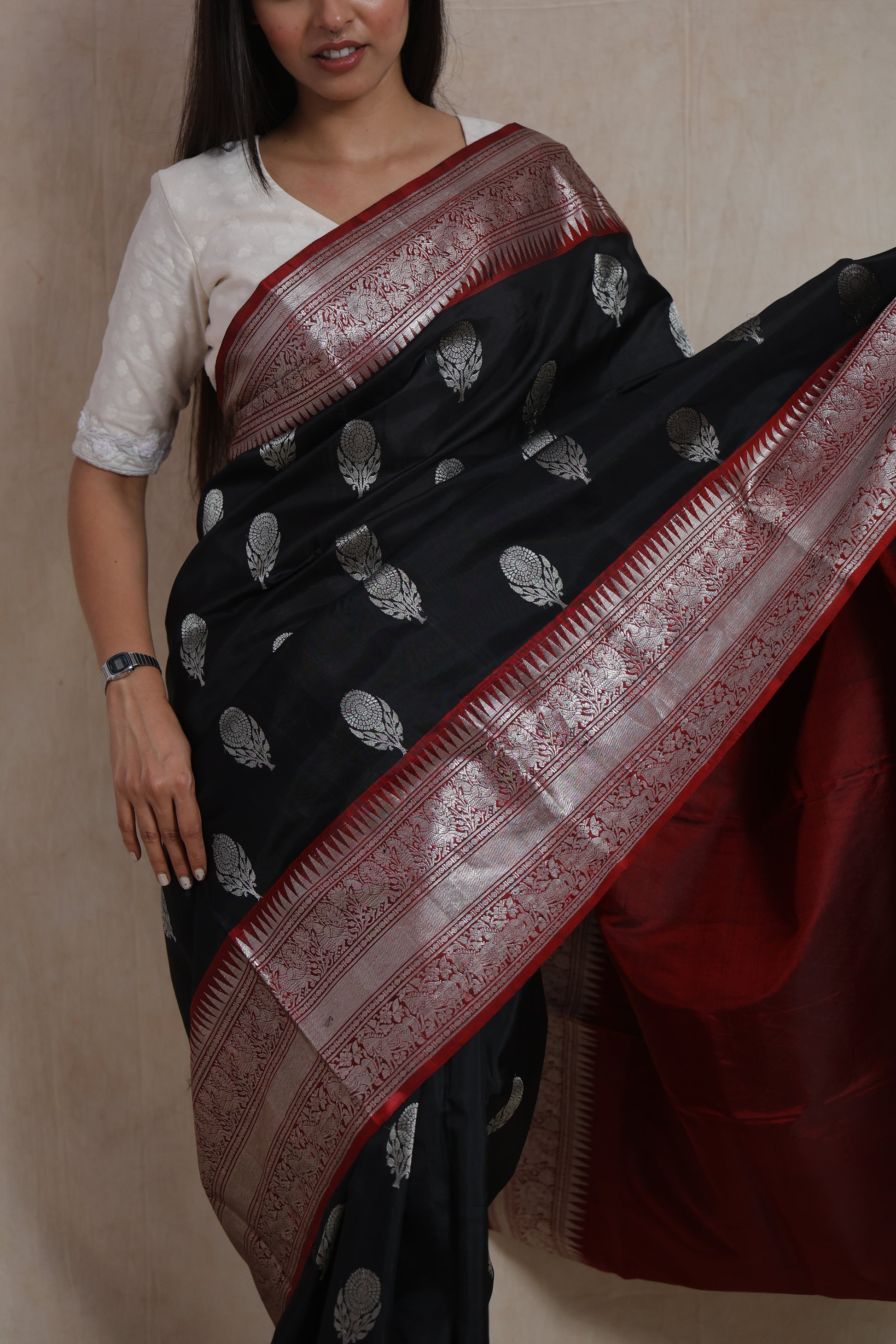 Close-up of the black Kanjivaram silk saree displaying silver woven buttas, detailed border, and premium silk texture.