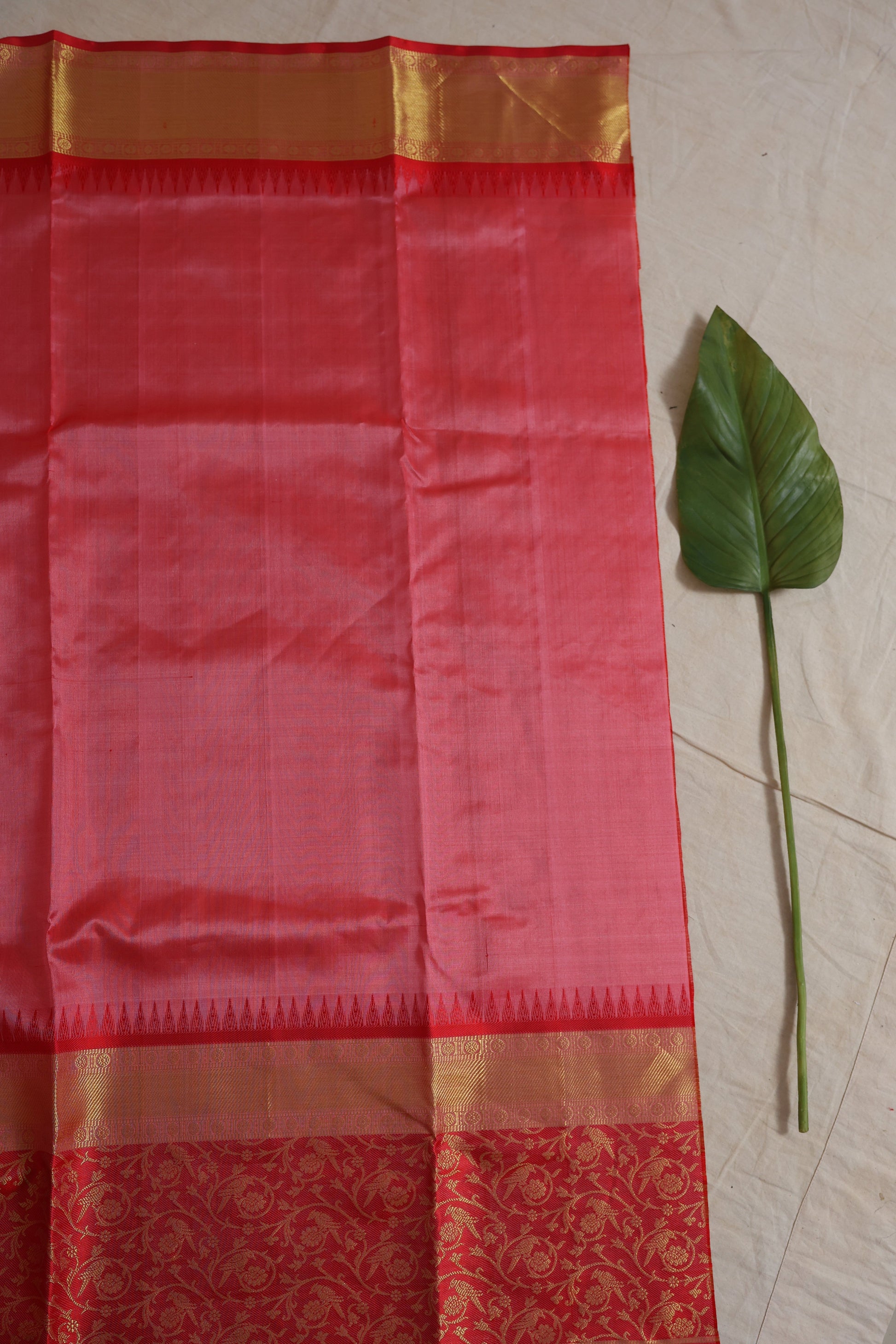 Close-up of the blush pink Venkatgiri silk saree displaying gold woven checks, elegant border, and richly woven floral pallu.