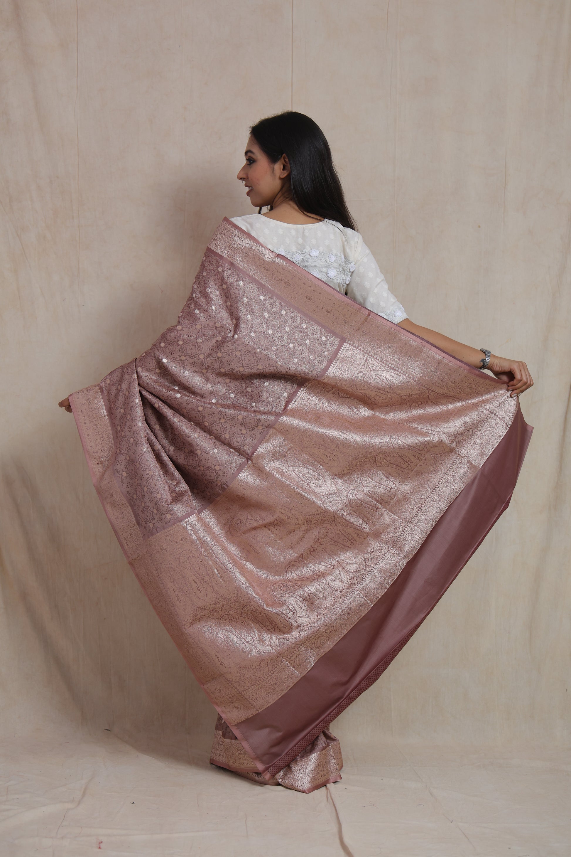 Back drape view of dusty rose Banarasi art silk saree highlighting detailed woven pallu