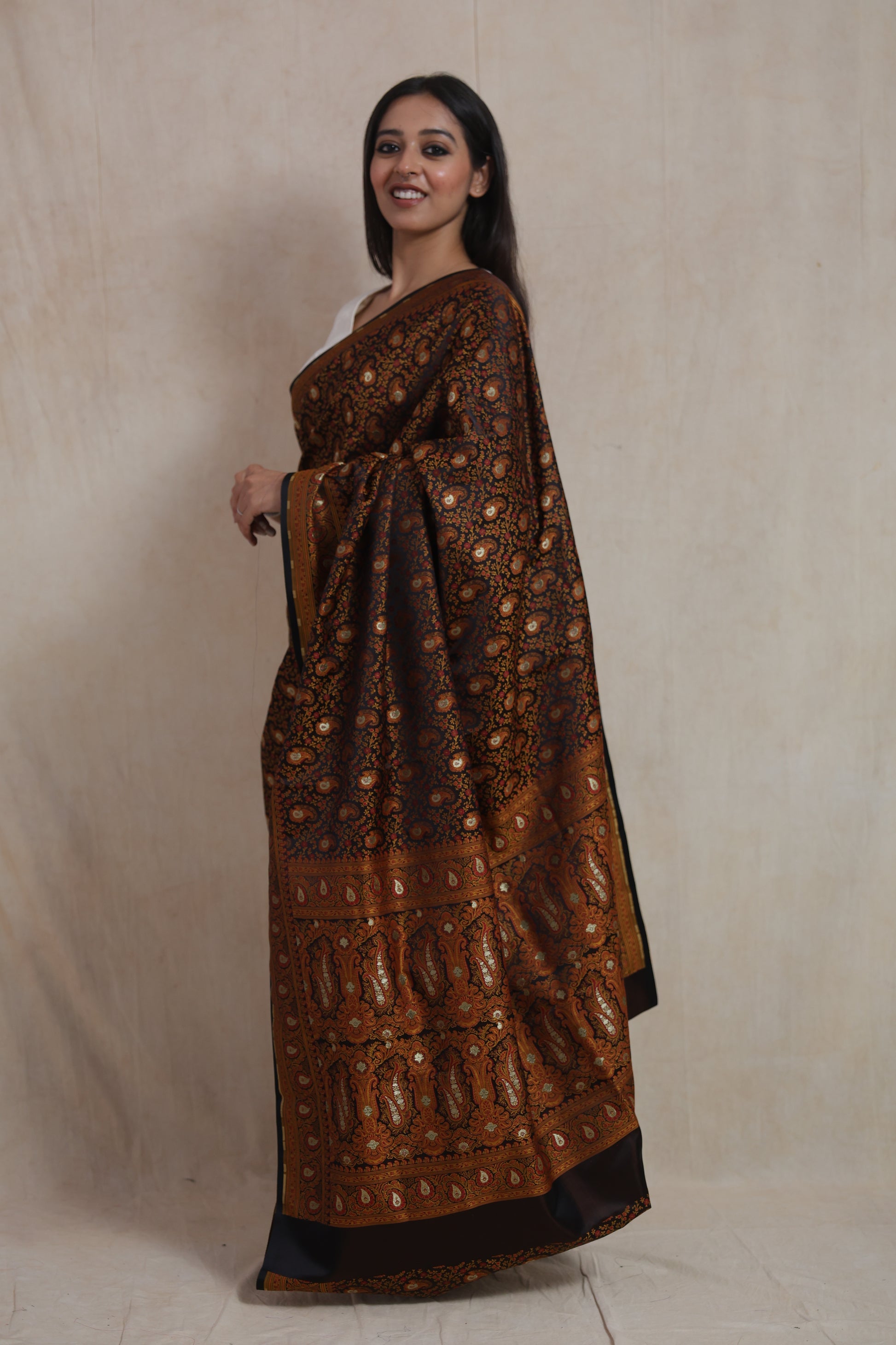 Side profile of model wearing black Banarasi silk saree with traditional pallu