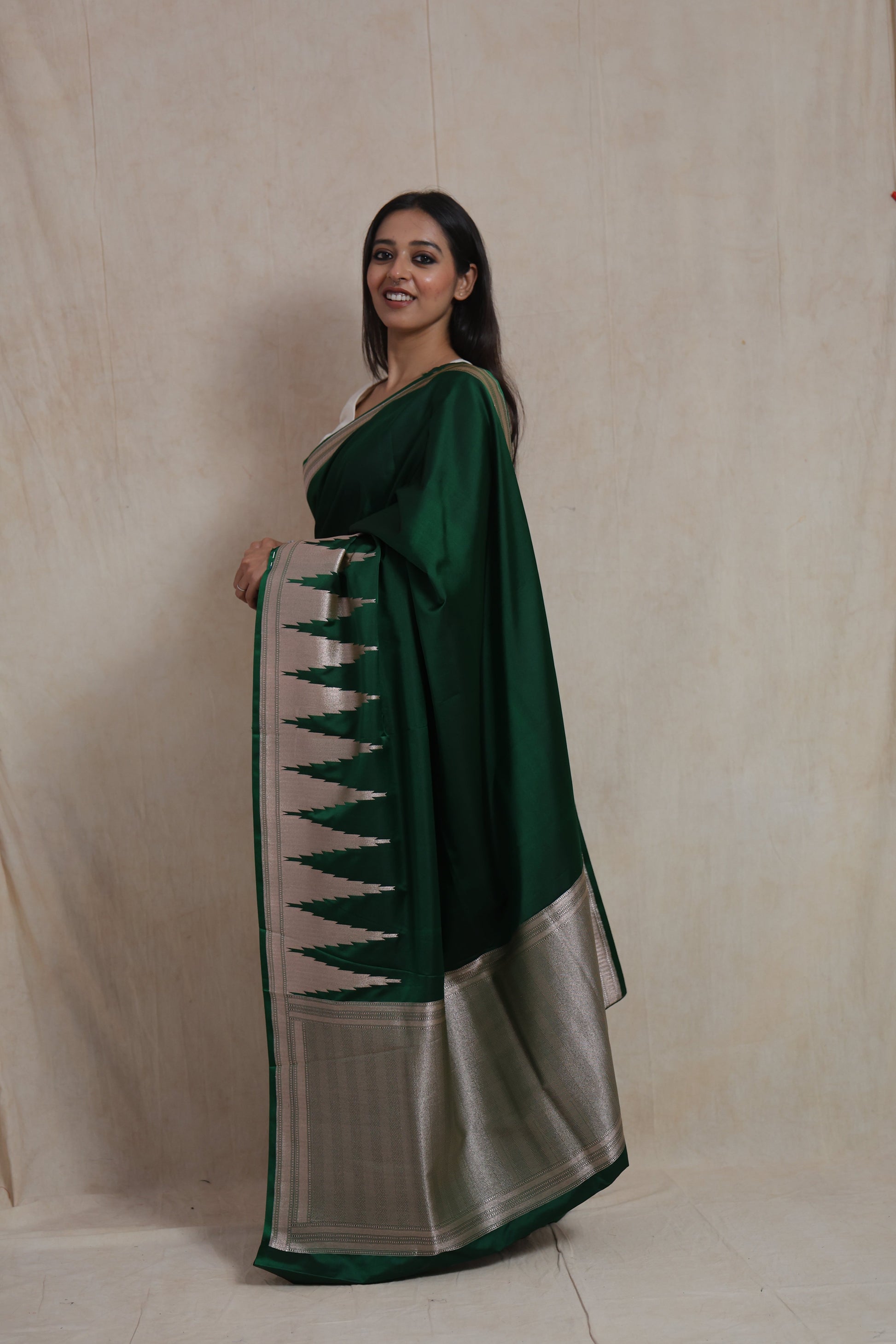 Side profile of emerald green Banarasi art silk saree showcasing silver woven pallu and border