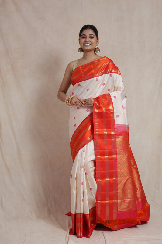 Ivory white Kanjivaram pure silk saree with pink buttas and vibrant coral orange border