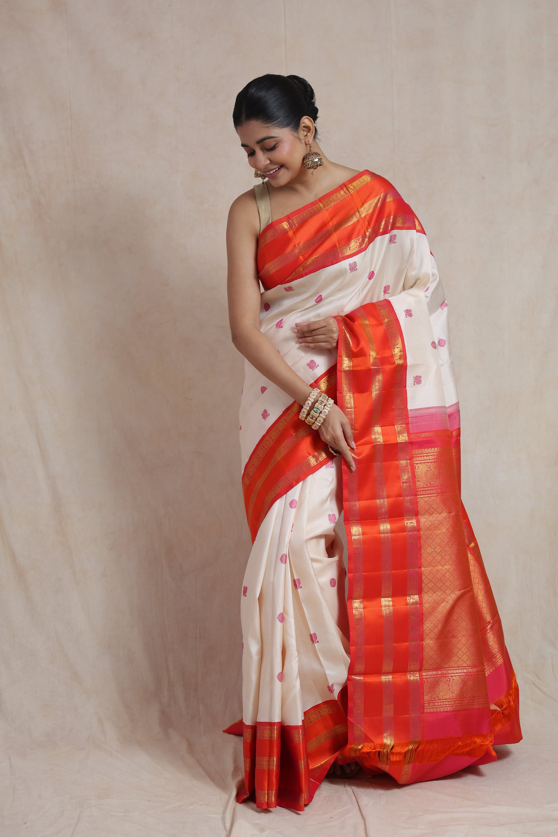 Elegant drape of ivory white Kanjivaram silk saree featuring woven pink motifs and rich border