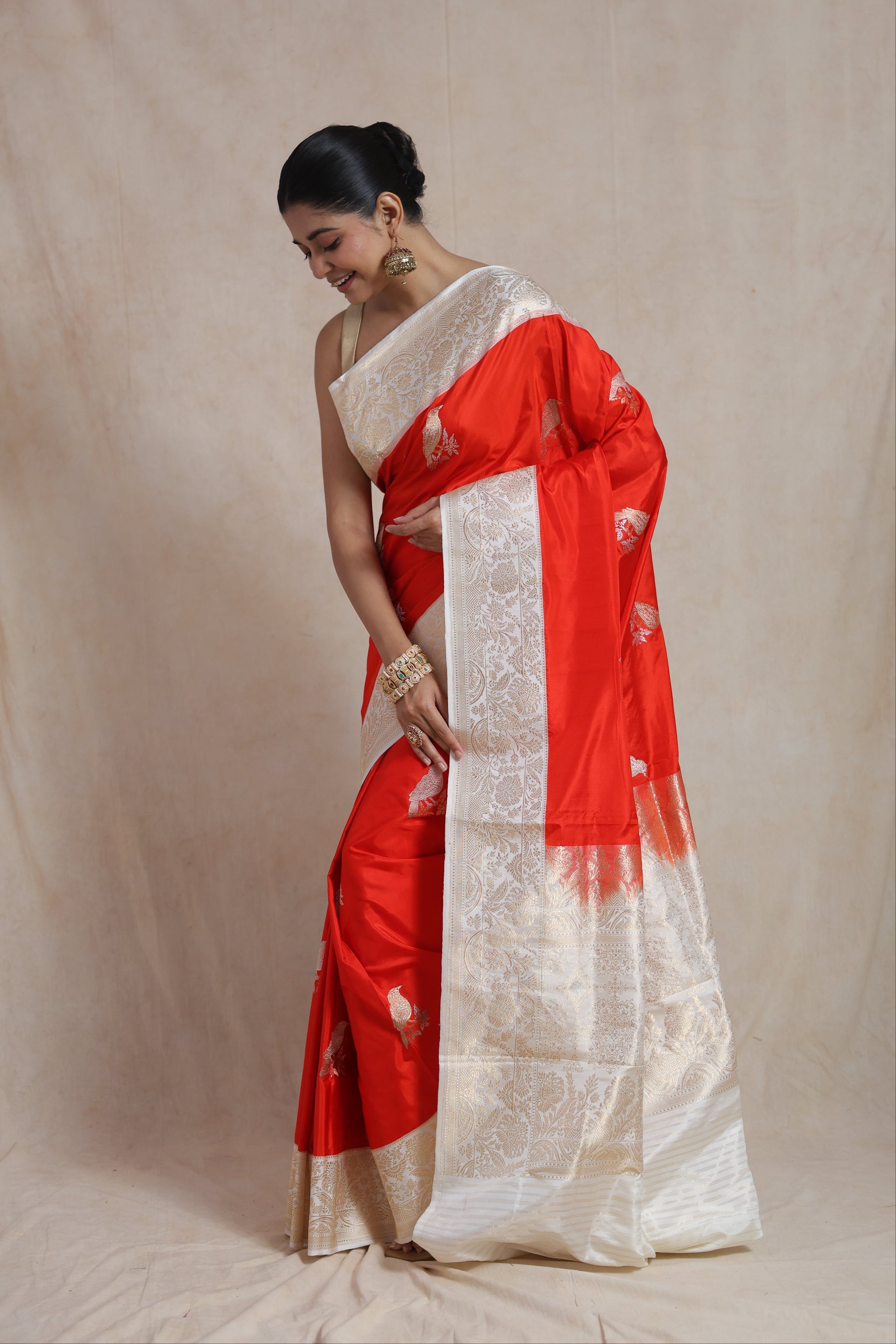 Detailed view of floral woven border and bird motifs on vermilion red Banarasi silk saree
