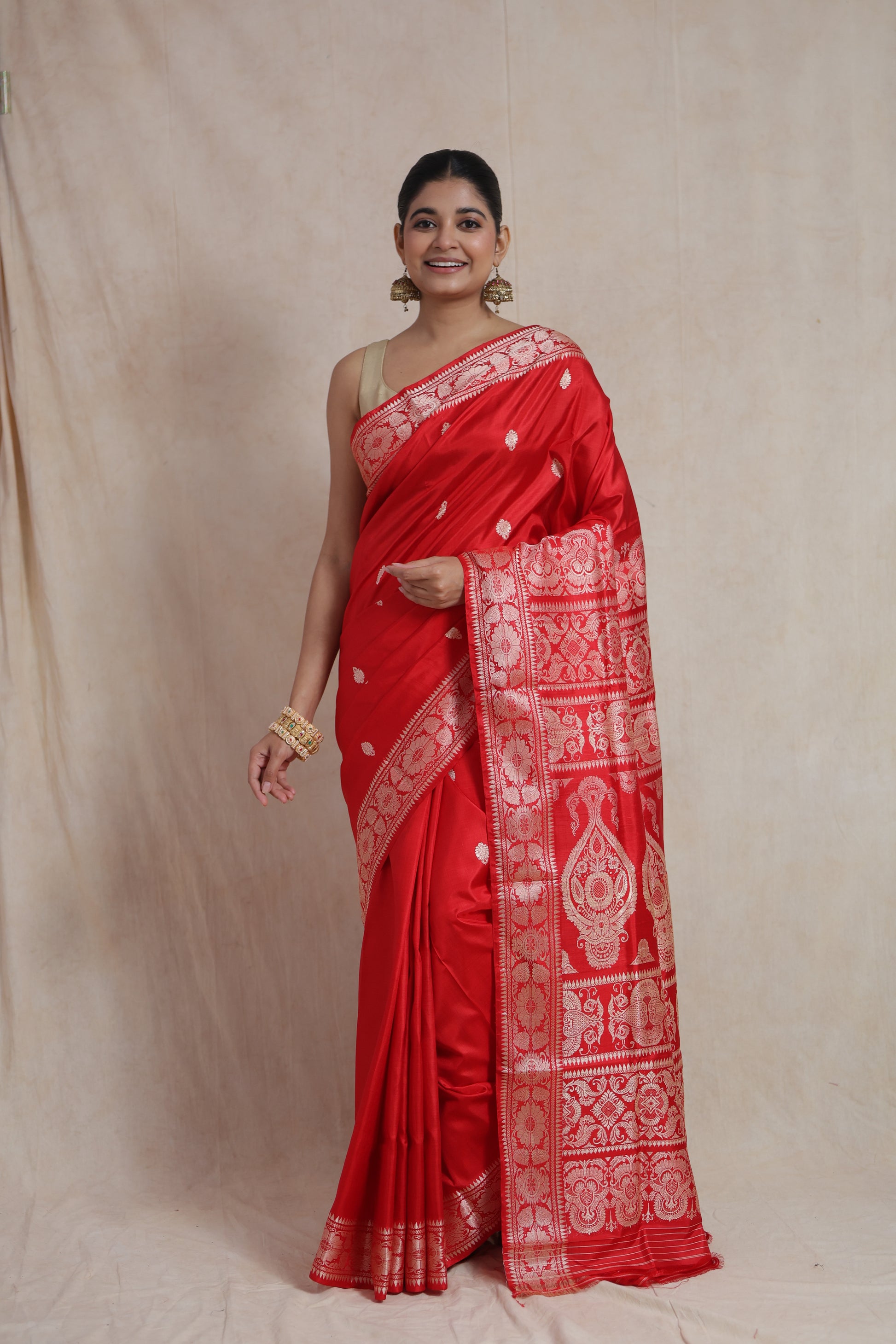 Front view of a royal red Banarasi silk saree featuring delicate woven buttas, an elegant floral border, and a richly woven traditional pallu.