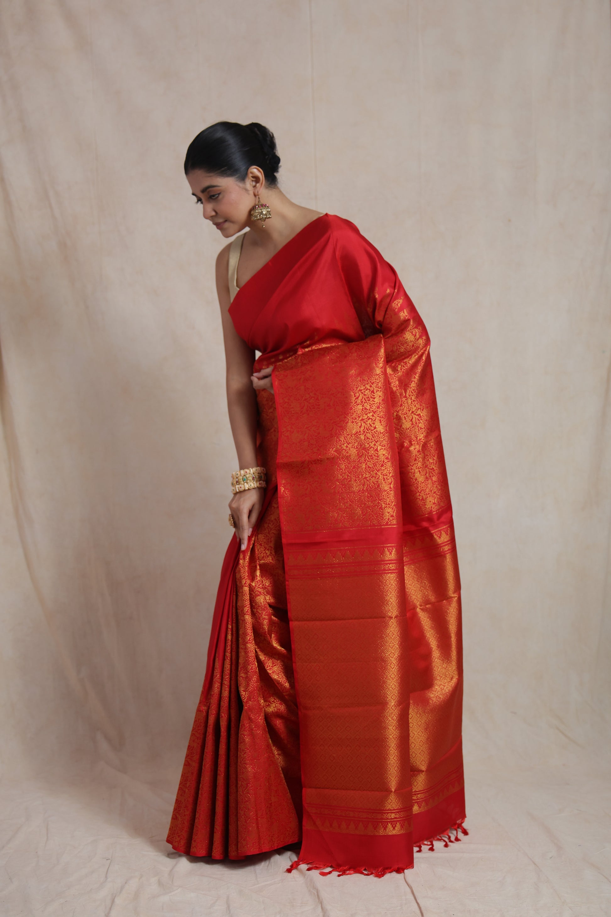 Side view of radiant red Kanjivaram silk saree showcasing elegant woven pallu and luxurious drape