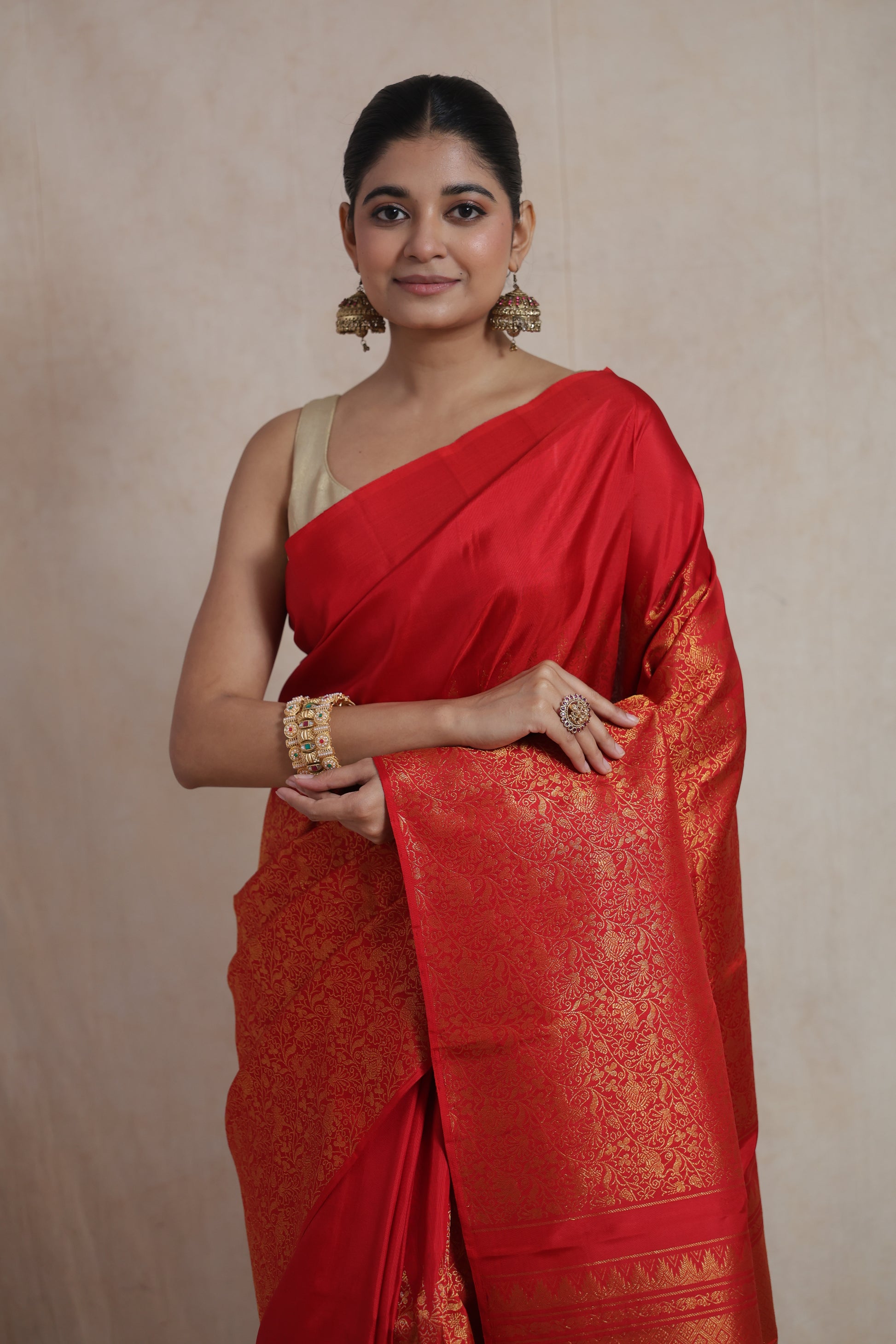 Portrait view highlighting the rich silk texture and intricate woven design of the red Kanjivaram saree.