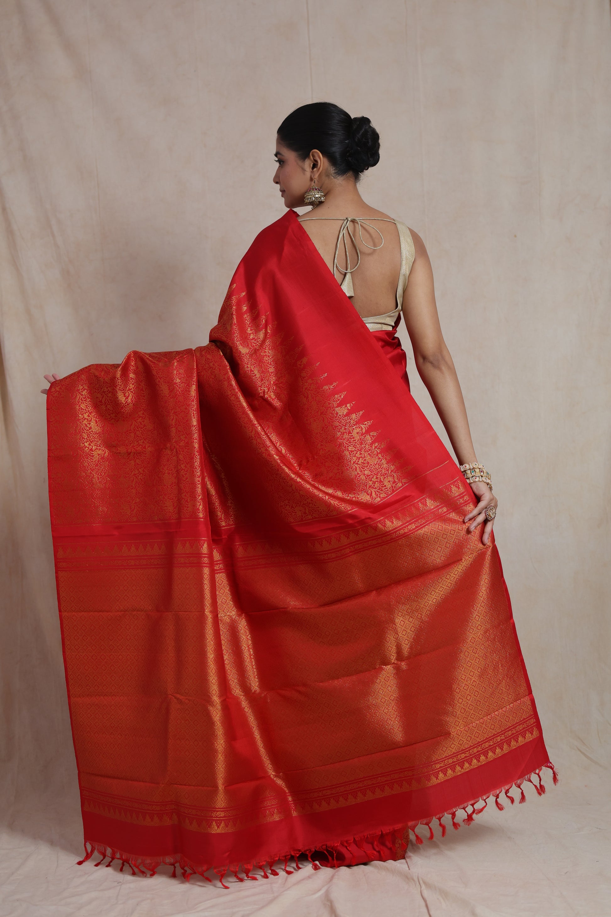 Back view displaying the grand woven pallu of the radiant red Kanjivaram silk saree.