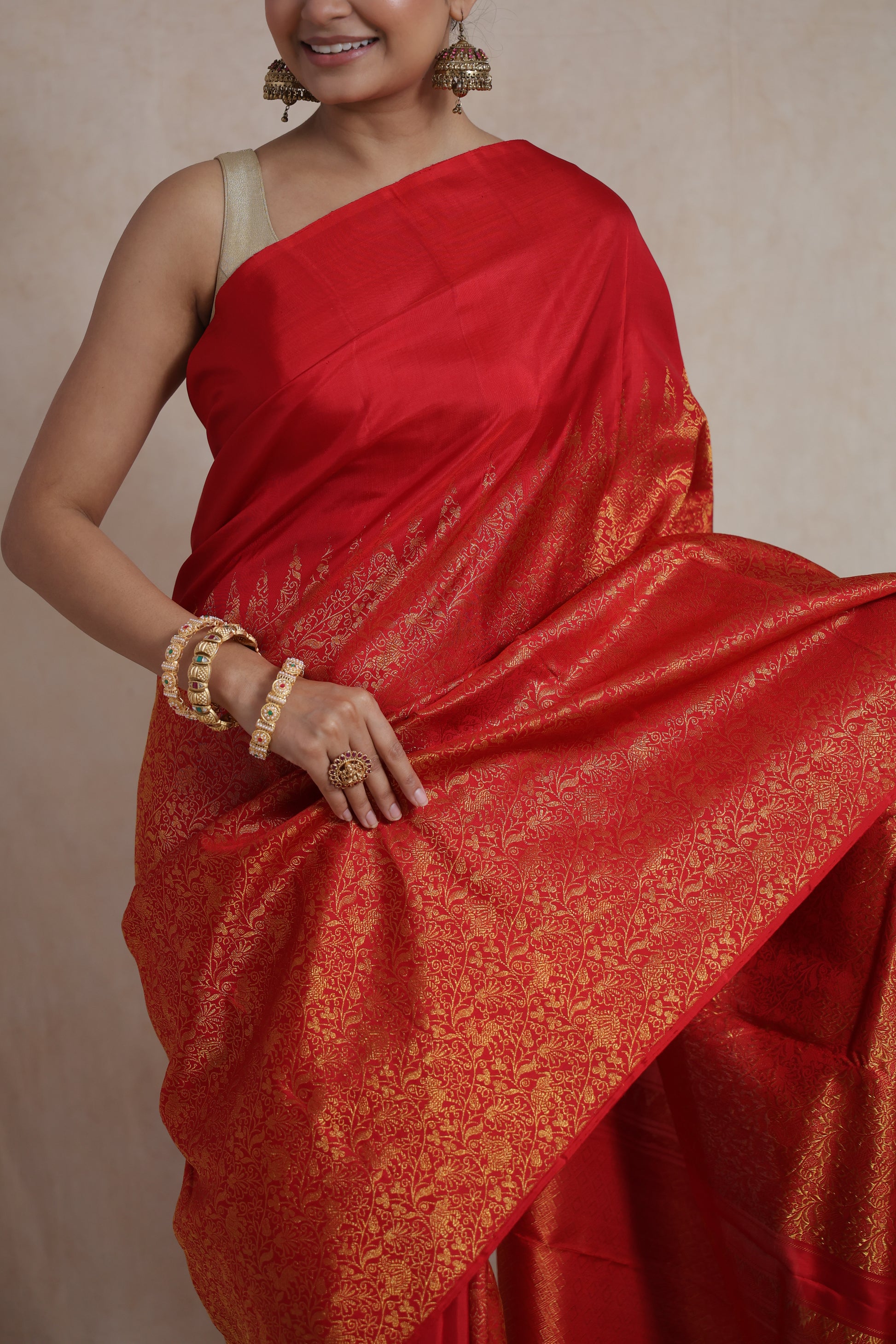 Close-up of the woven floral body and luxurious border of the red Kanjivaram silk saree.