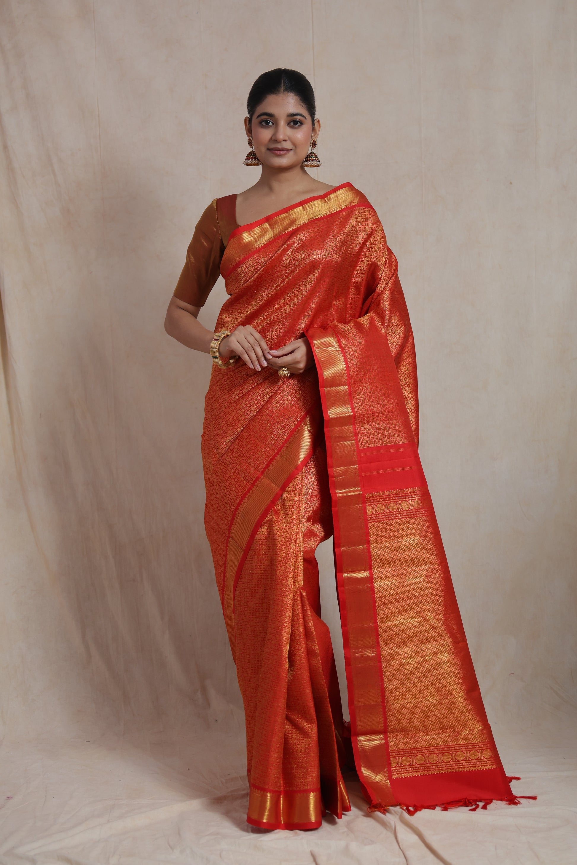 Front view of vermilion red Kanjivaram pure silk saree with intricate woven patterns and traditional border