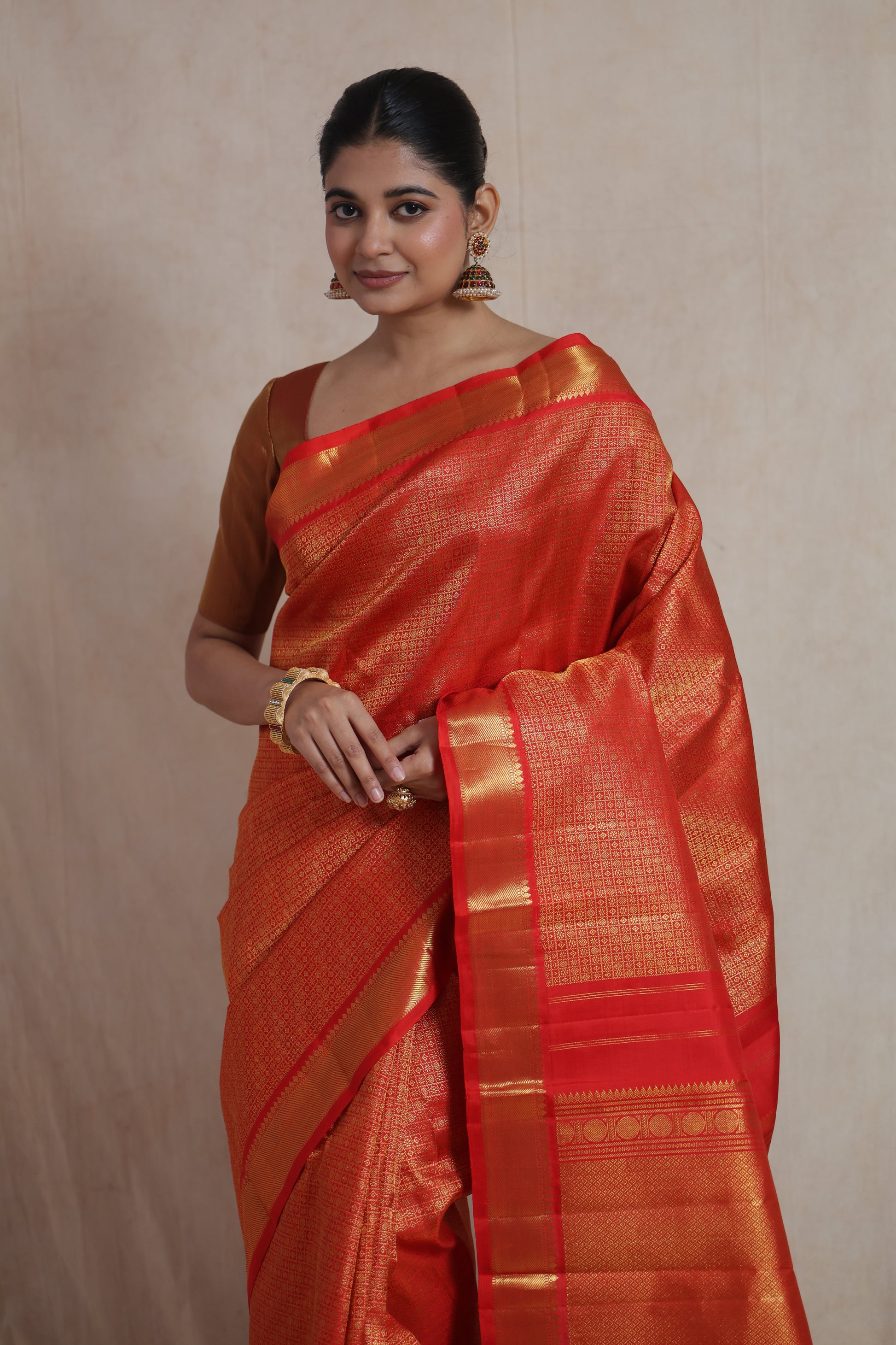 Close-up of vermilion red Kanjivaram pure silk saree showcasing detailed traditional weaving