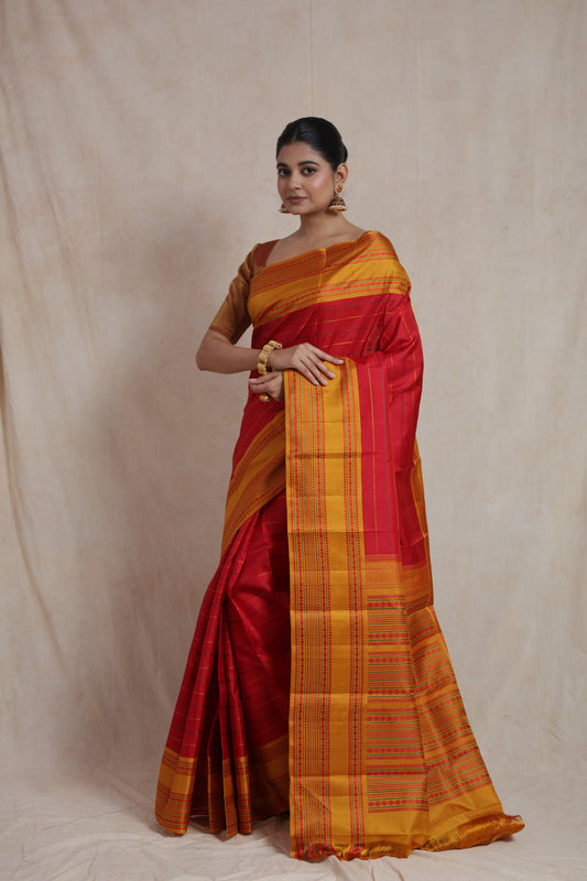 Detailed view of mustard gold woven border and traditional motifs on red Kanchipuram silk saree