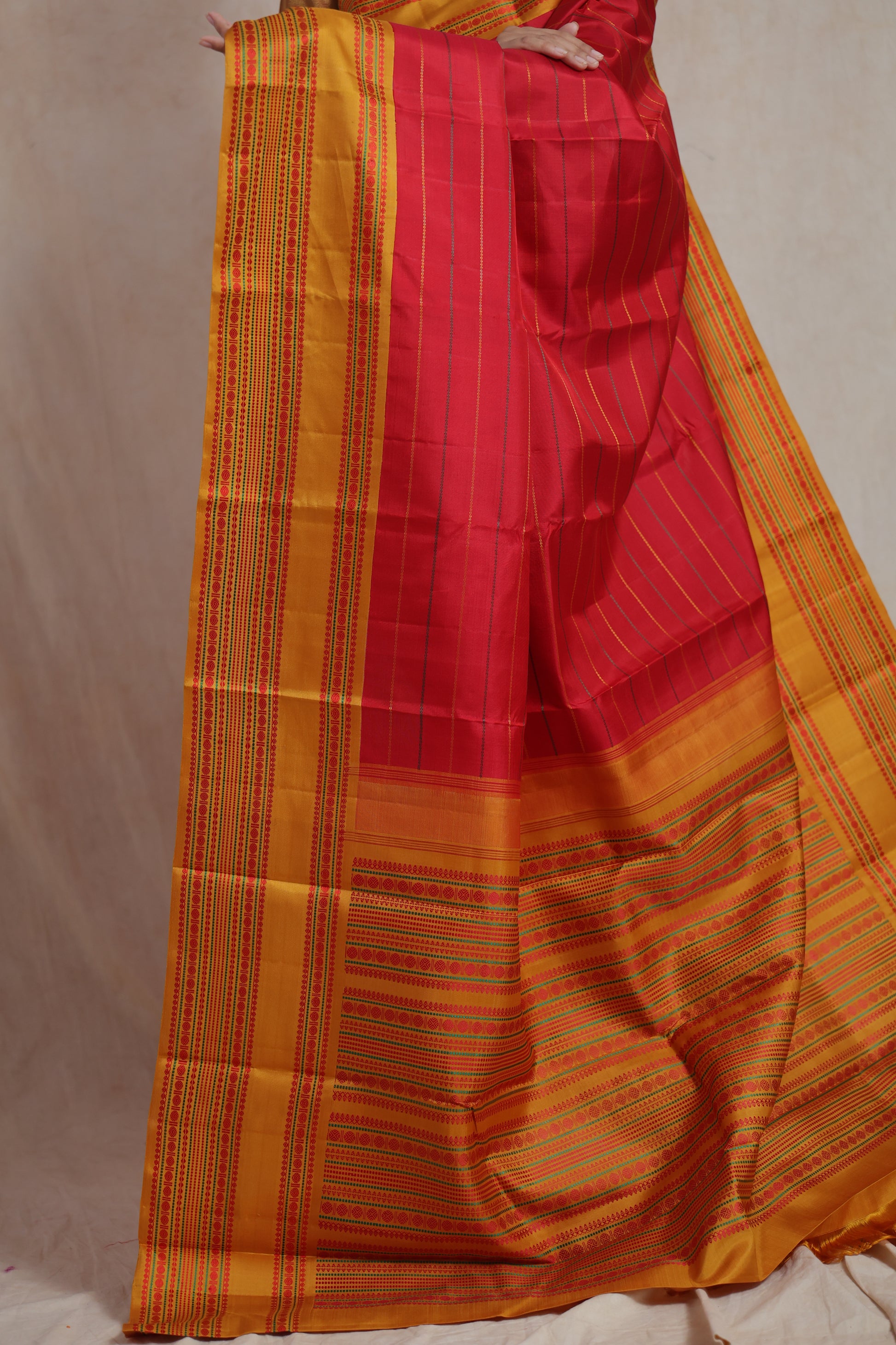 Crimson red Kanchipuram silk saree with mustard gold woven border and traditional striped pattern