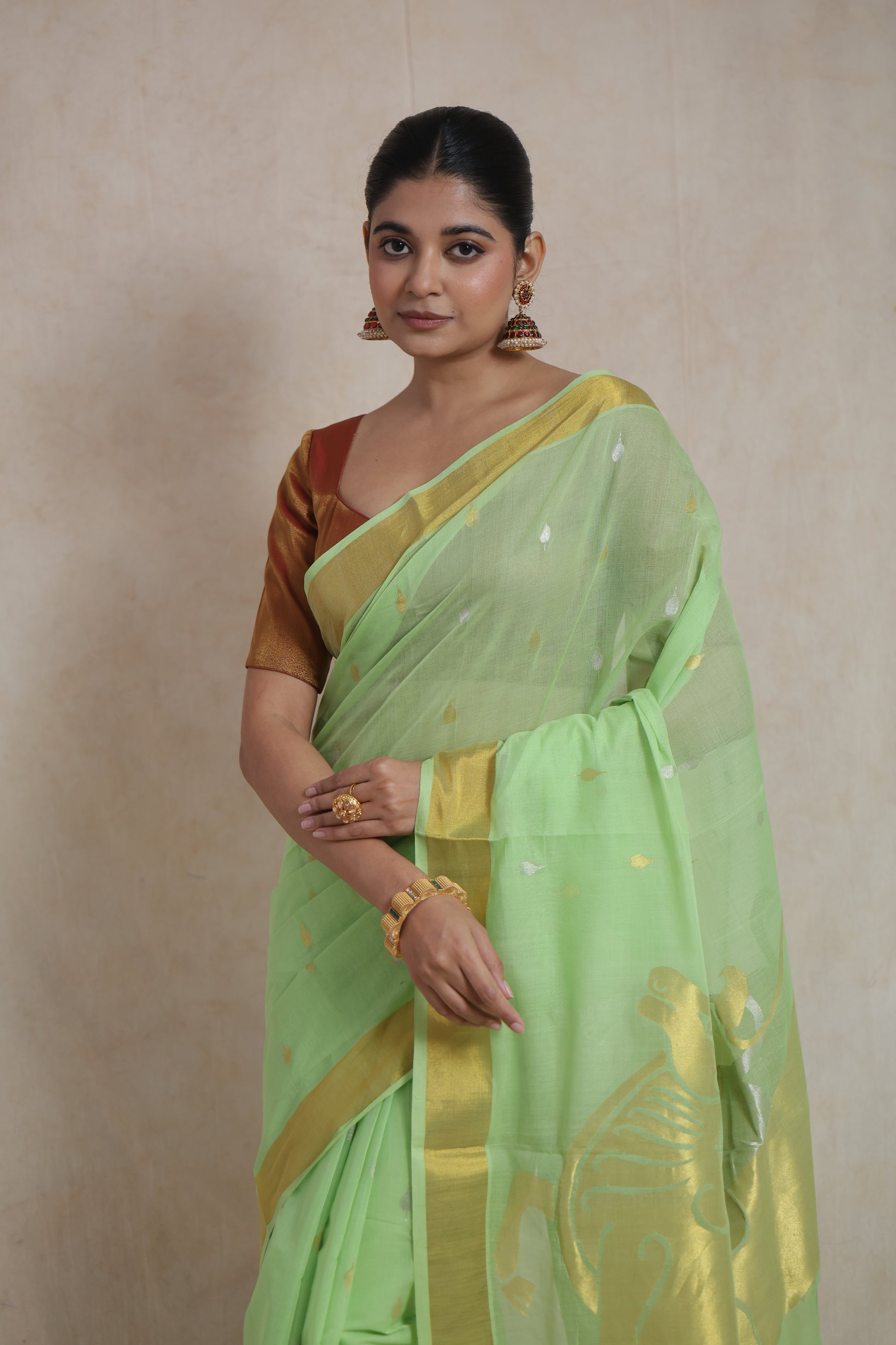 Portrait view of mint green Kanchipuram cotton saree with delicate woven buttas