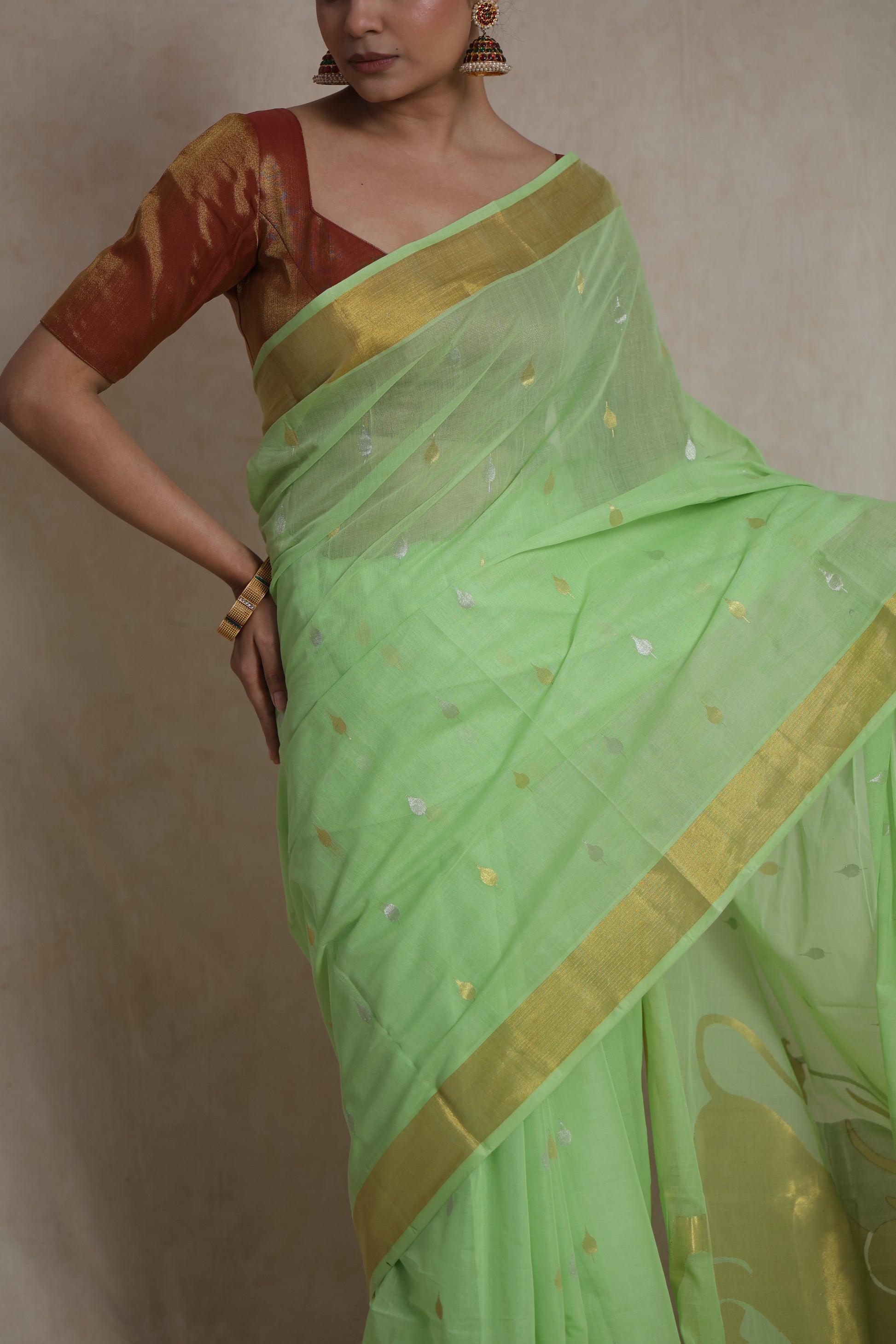 Close-up of woven buttas and border on mint green Kanchipuram cotton saree
