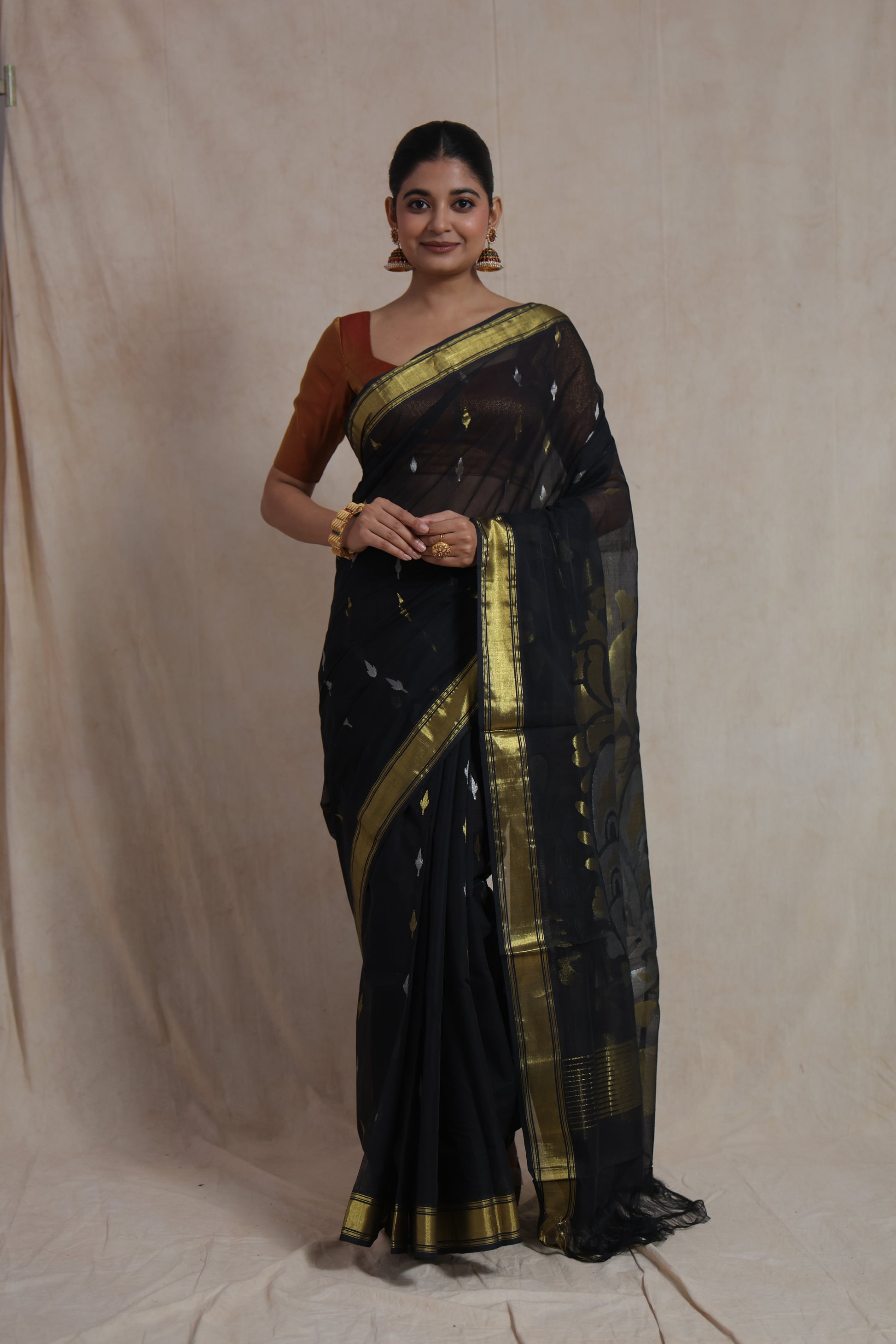 Front view of black Kanchipuram handloom cotton saree with woven motifs and contrast border