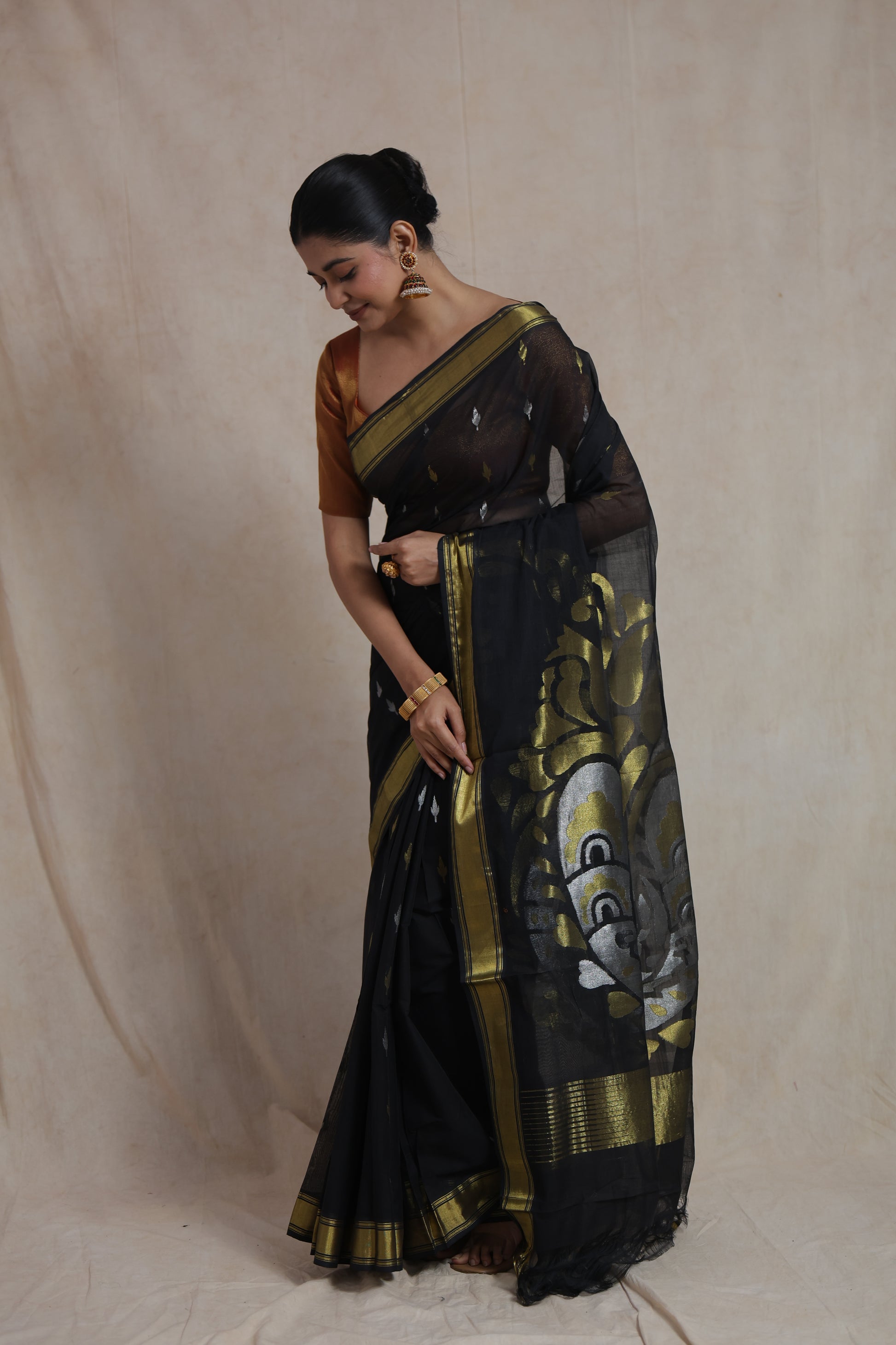 Elegant drape of black Kanchipuram cotton saree with traditional woven detailing