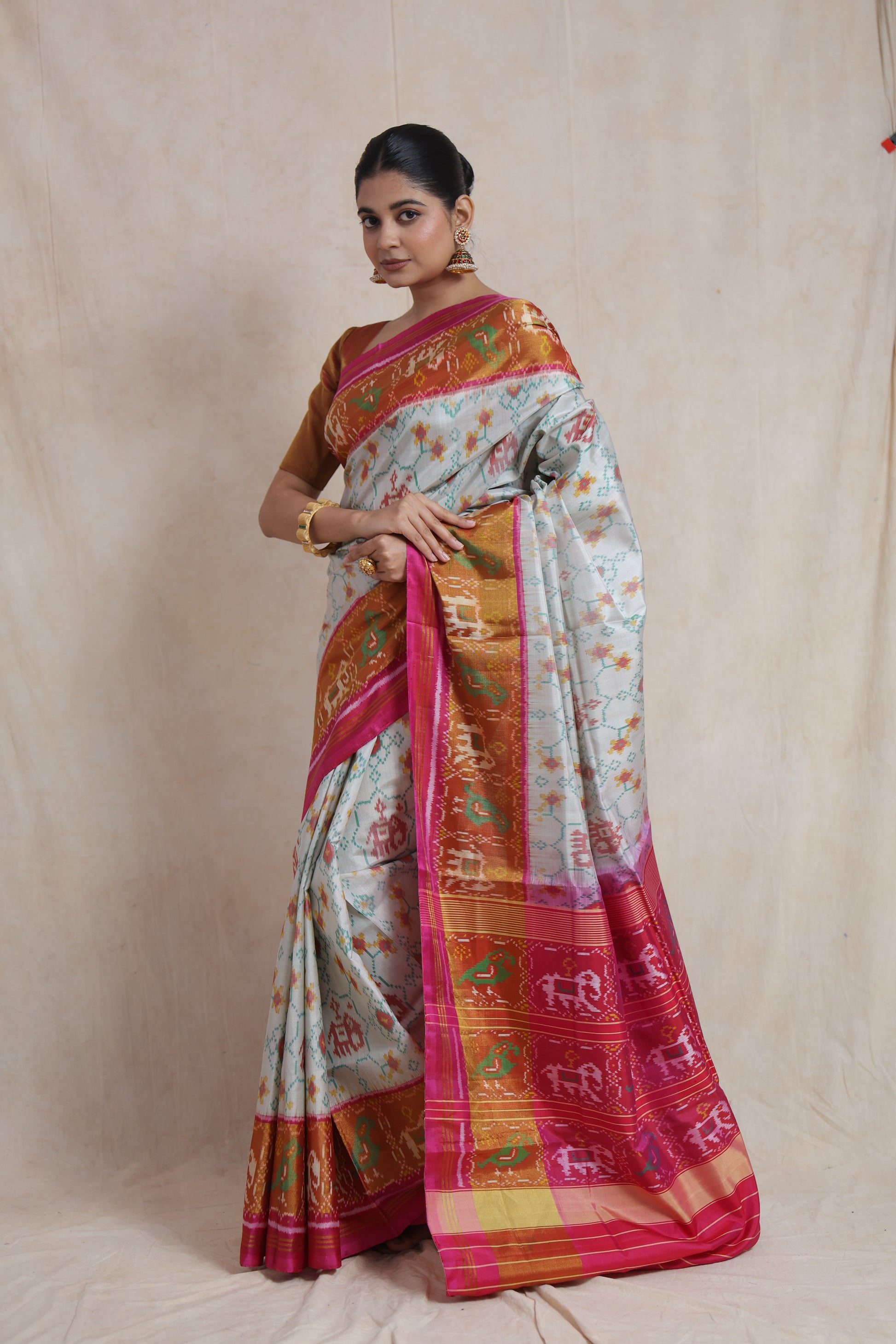 Side view of ivory Patola silk saree with vibrant woven border