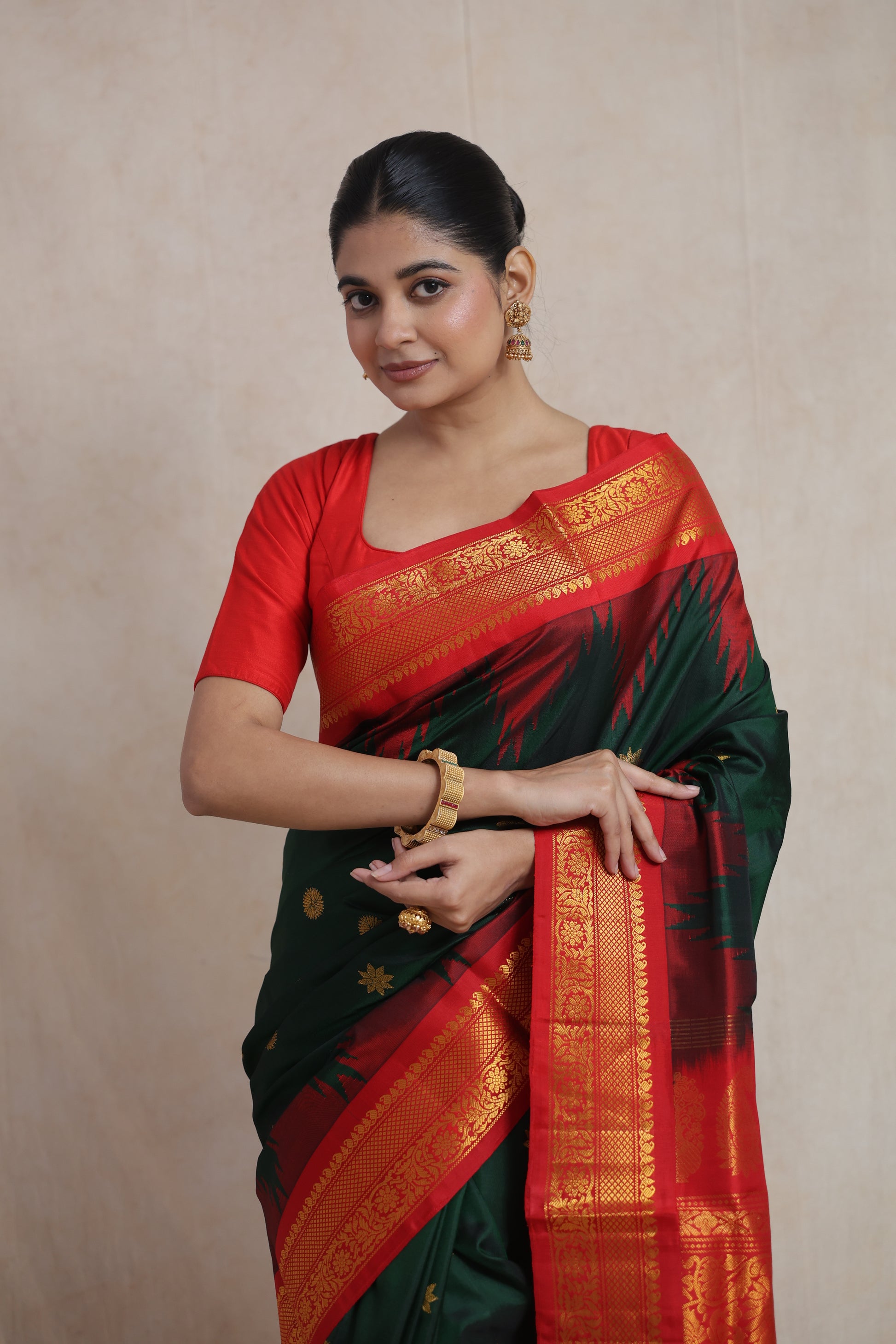 Close-up drape view of forest green Gadwal silk saree with woven motifs and red border