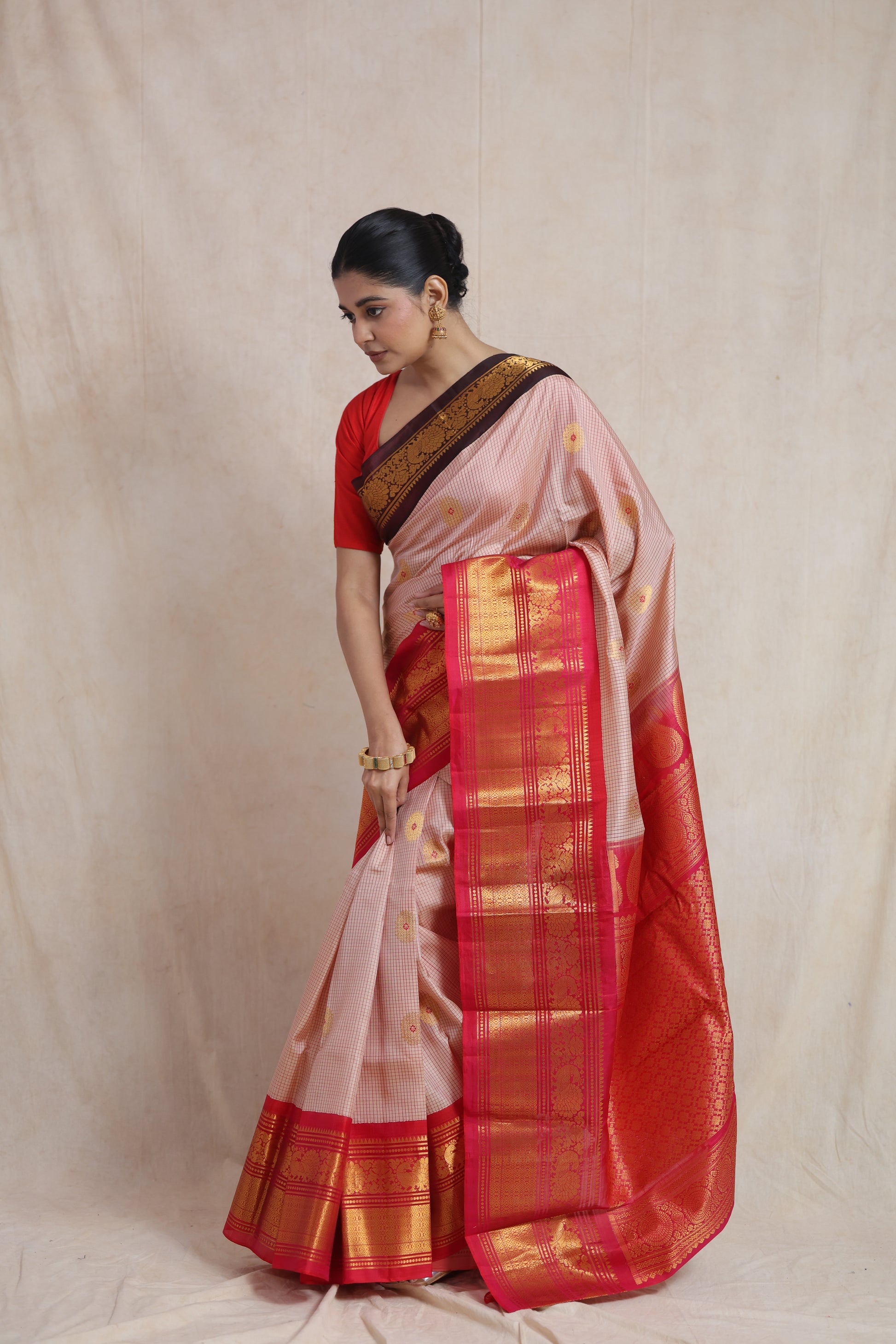 Side view of ivory beige Gadwal silk saree showcasing rich red woven border detailing