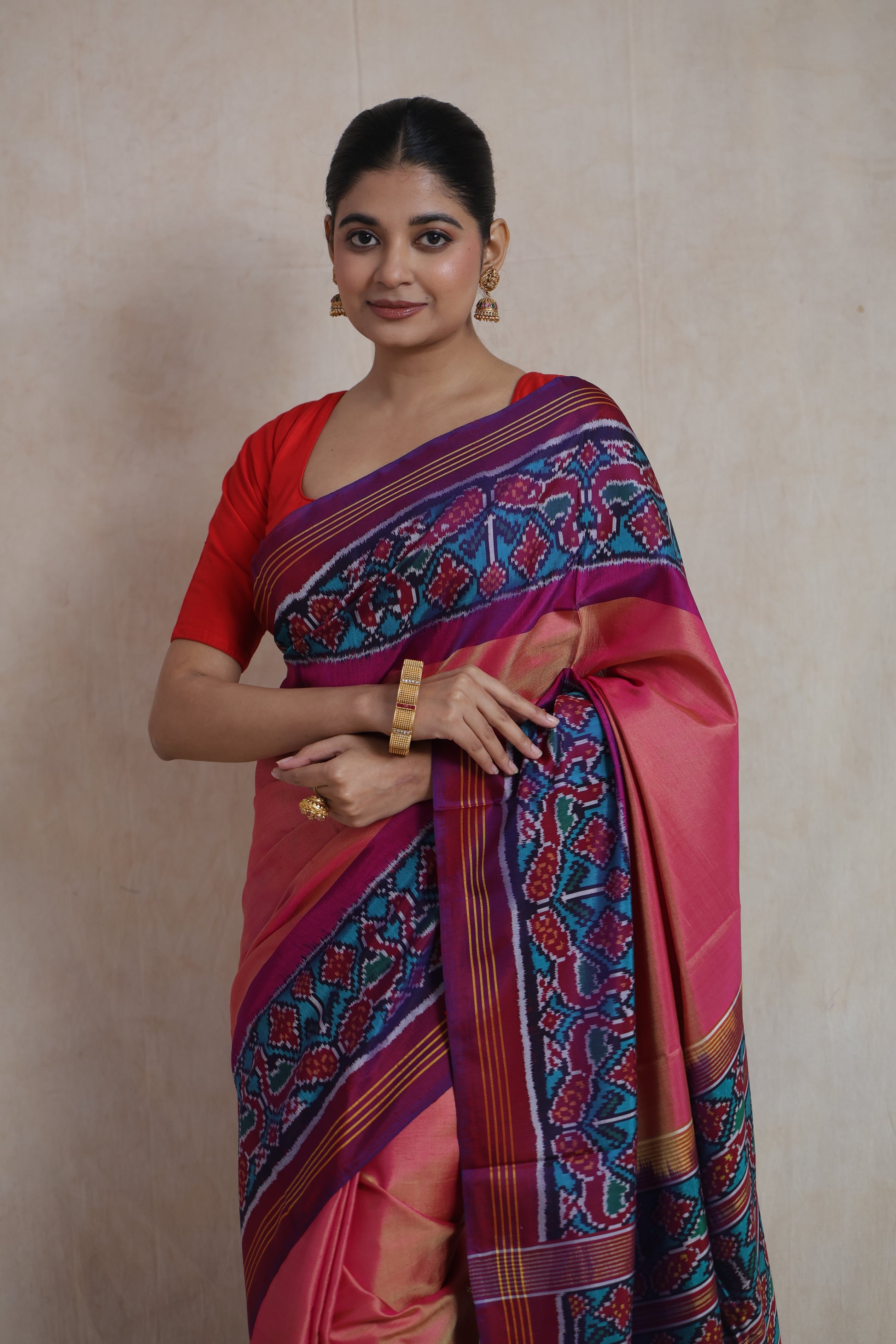 Close-up of peach pink Patola silk saree featuring vibrant Ikat border
