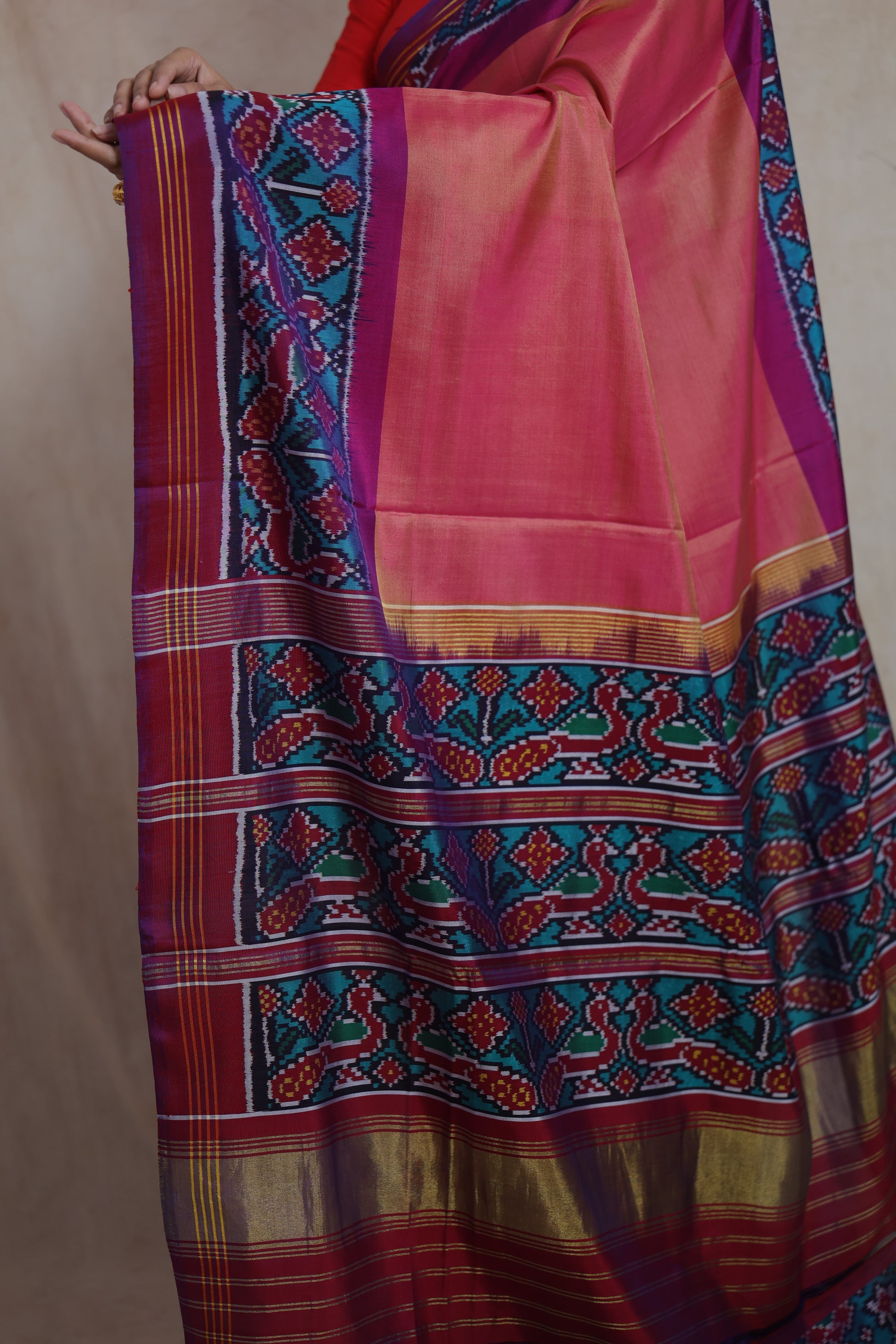 Rich pallu detail of the peach pink Patola silk saree with geometric Ikat motifs